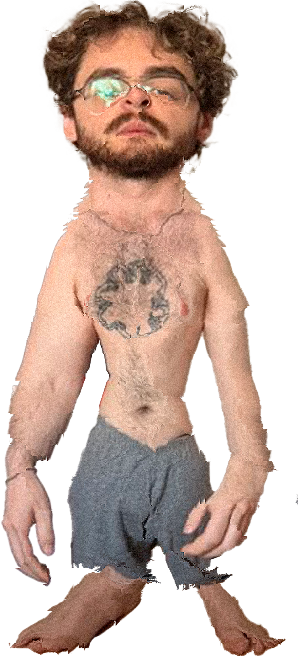 Hombre con barba y gafas, sin camisa, con tatuaje en el pecho, usando shorts grises y descalzo.