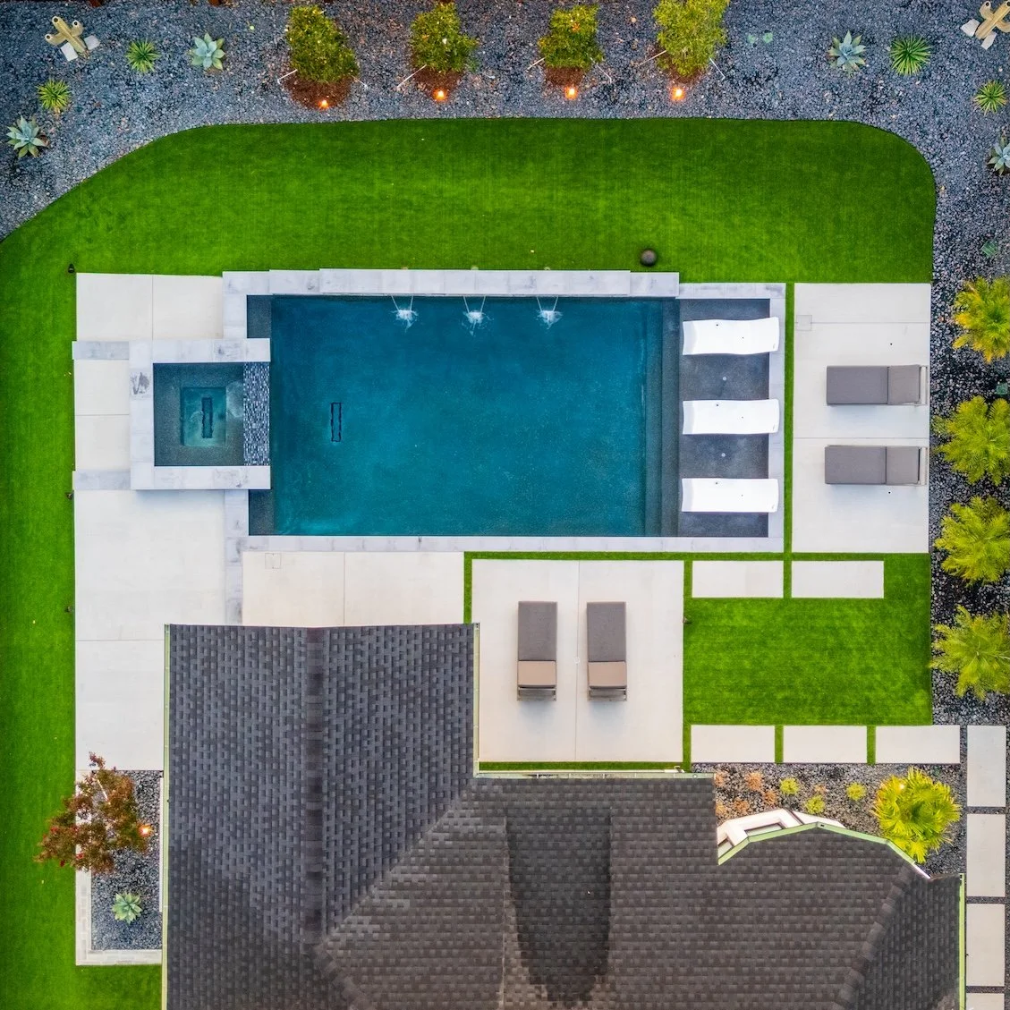 Leschber Designs custom builder pool and spa with decking, turf, tanning ledge, landscaping, and water features
