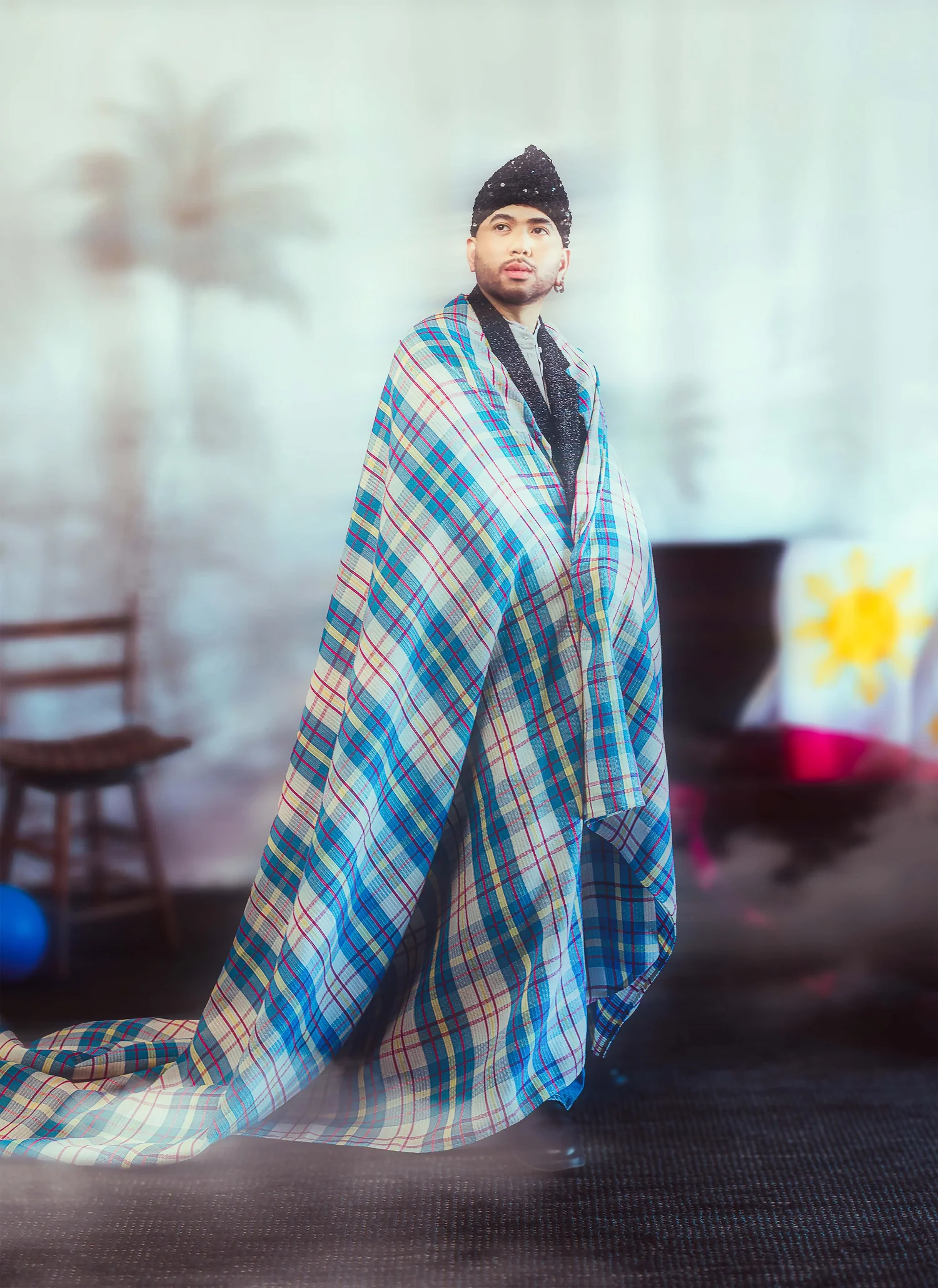 A man wrapped in a blue plaid blanket, from DIWA's Prologue editorial