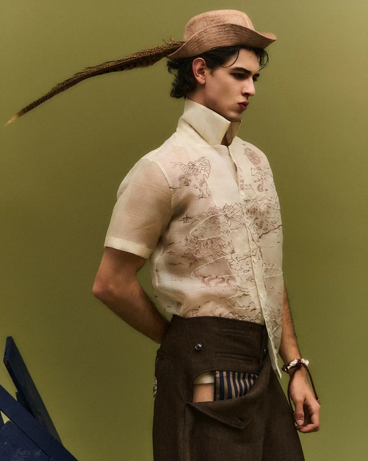 Model poses wearing sheer shirt with tattoo pattern.