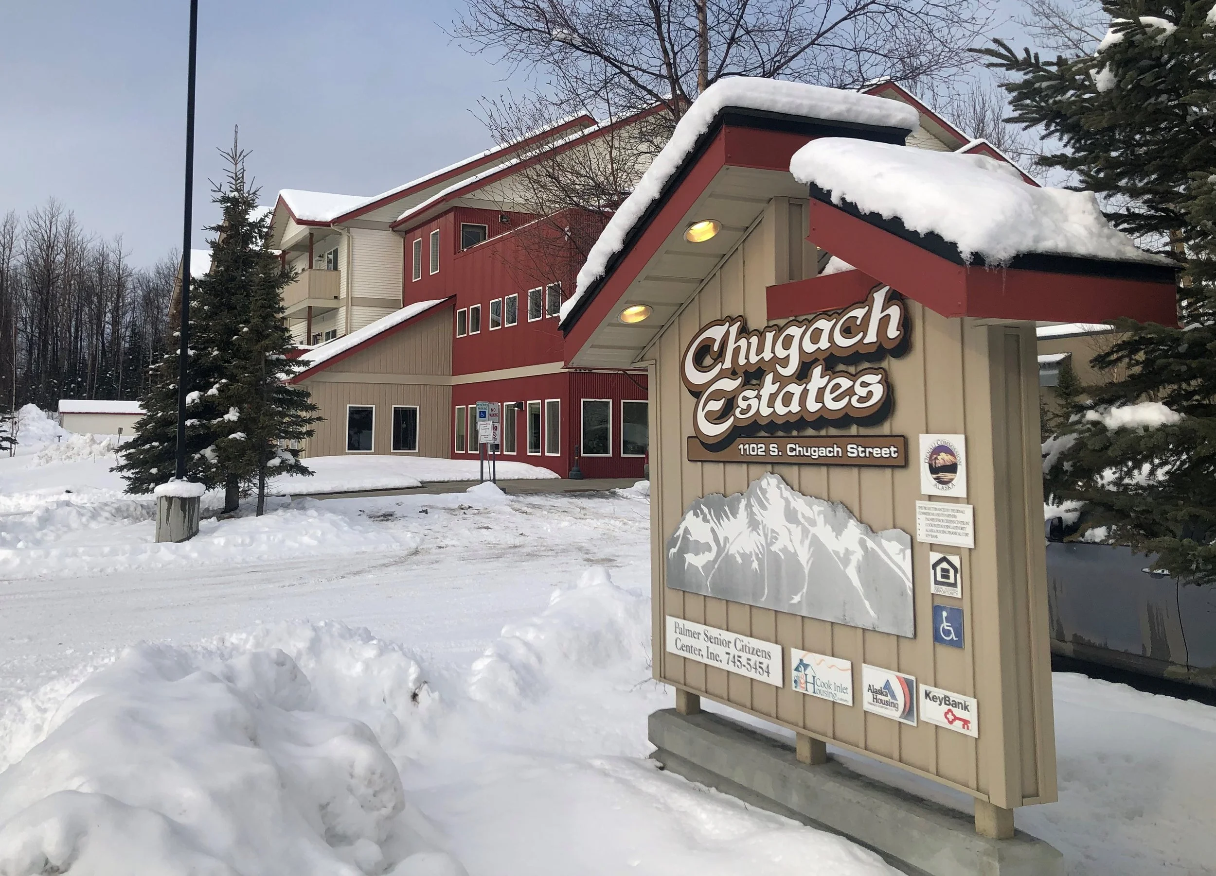 Snow-covered sign for Chugach Estates at 1102 S. Chugach Street in Alaska