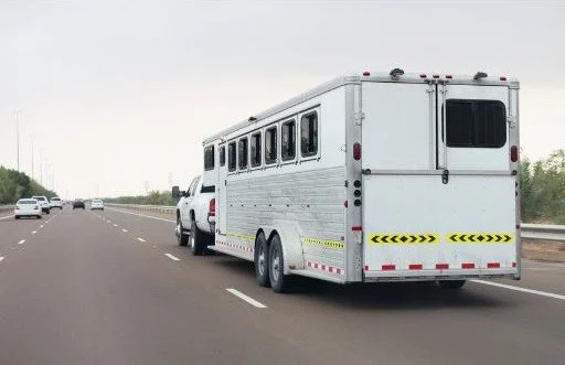 Horse trailer that can haul up to six horses driving down a six lane highway.