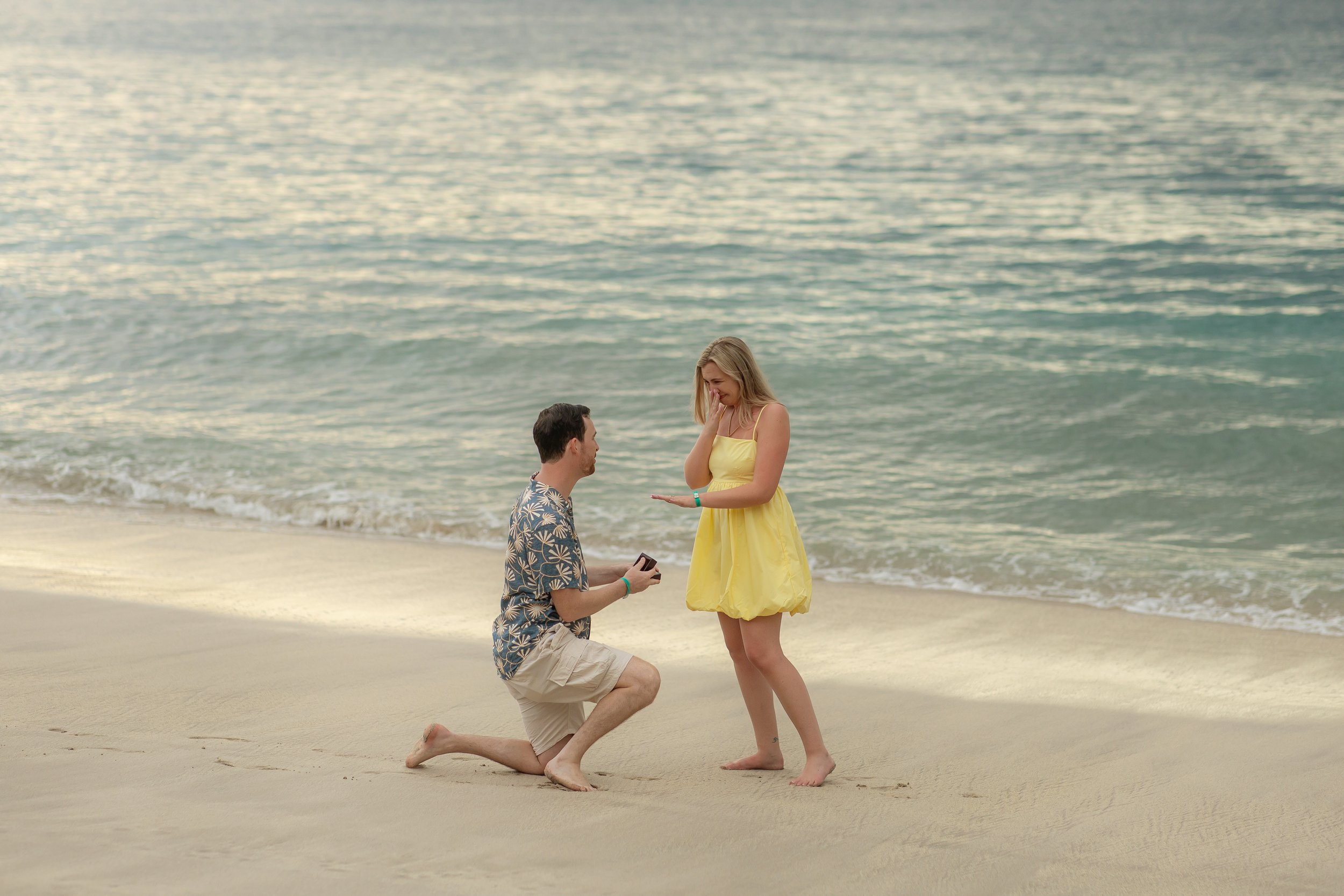 Connor proposing marriage to Kathleen on the beach in Costa Rica during sunset, with the ocean in the background.