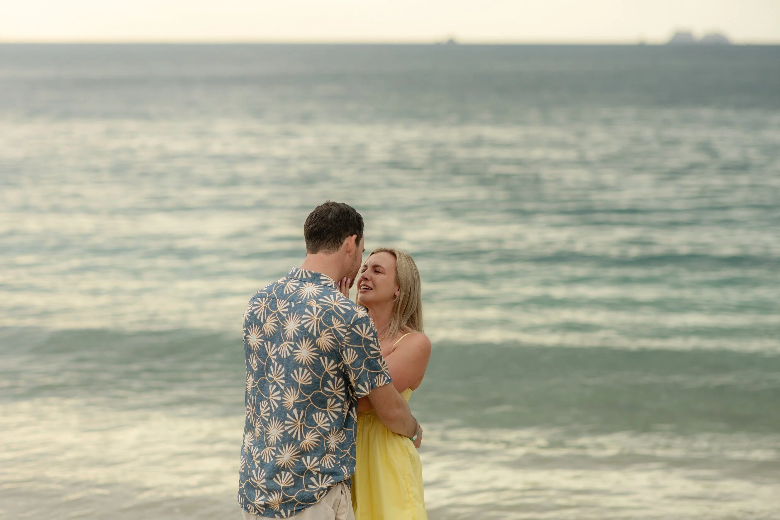 Connor proposing marriage to Kathleen on the beach in Costa Rica during sunset, with the ocean in the background.