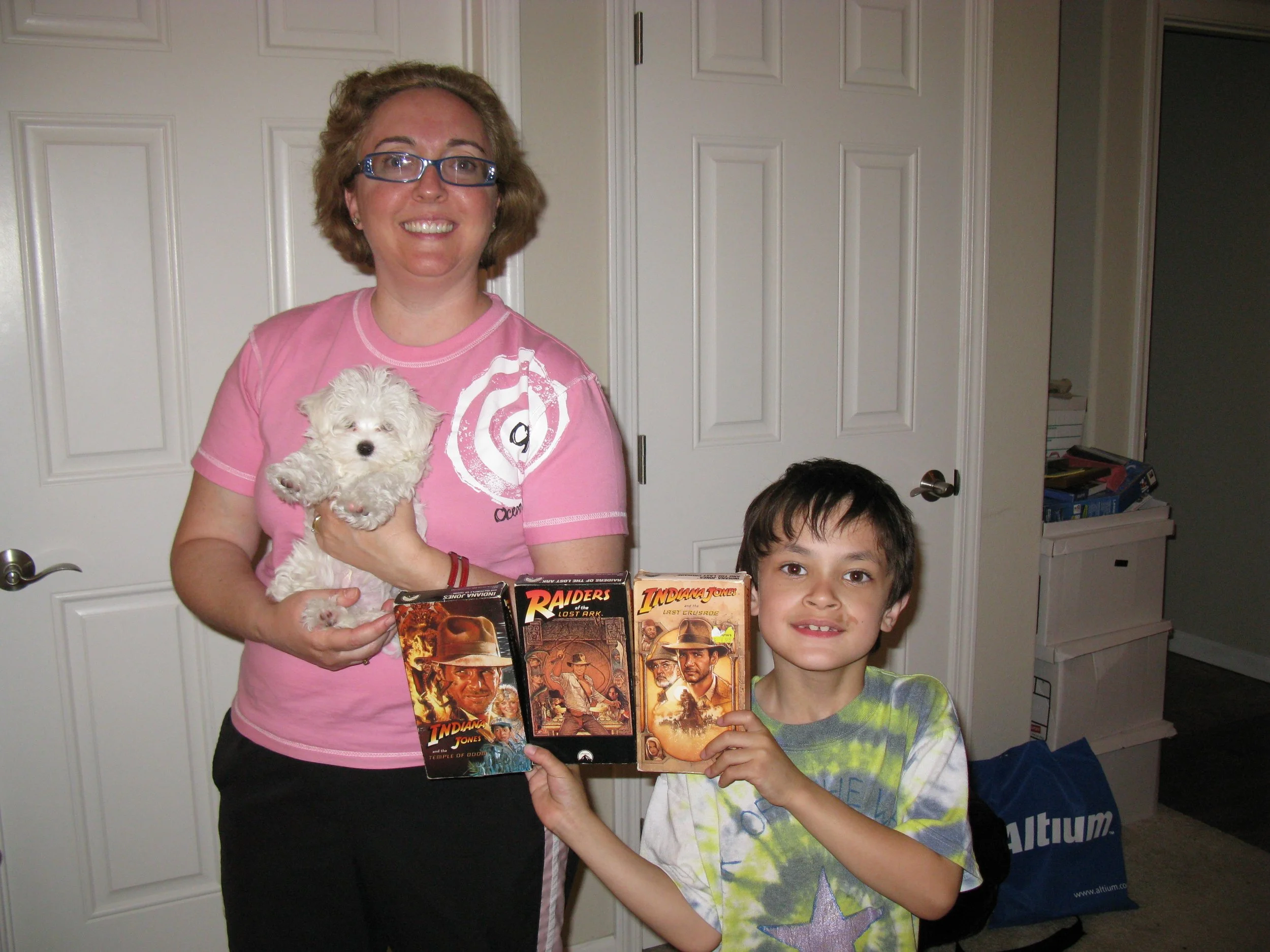 My mom holding our dog Twinkie and me with the Indiana Jones trilogy VHS tapes, 2008