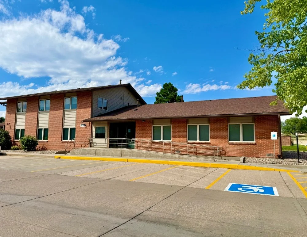 Front of the A Willow Bends Counseling Colorado Springs Location, showcasing a red brick exterior with parking spaces right at the entrance.