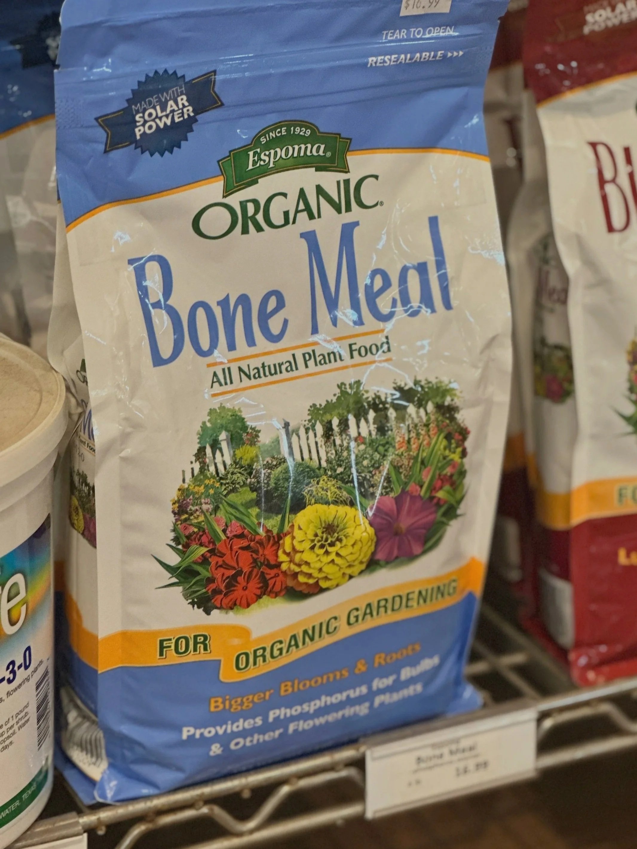 Bag of organic bone meal for gardening with illustrations of flowers and trees.