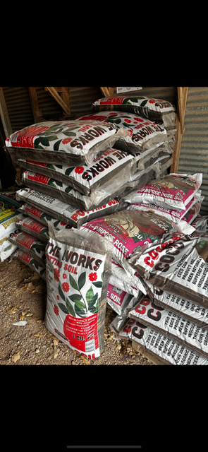 Stacked bags of potting soil in a store or garden center.