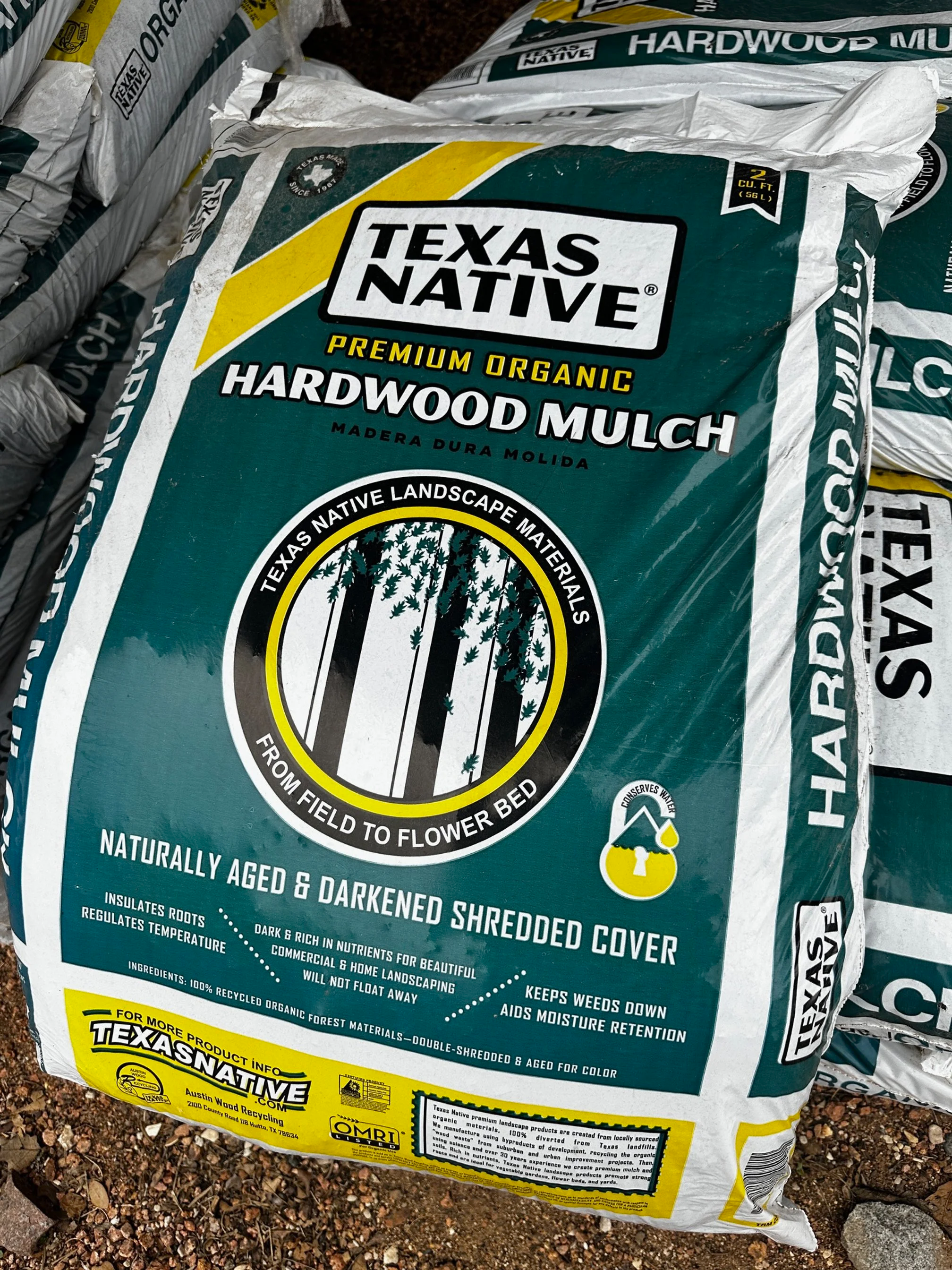 A bag of Texas Native premium organic hardwood mulch on the ground.