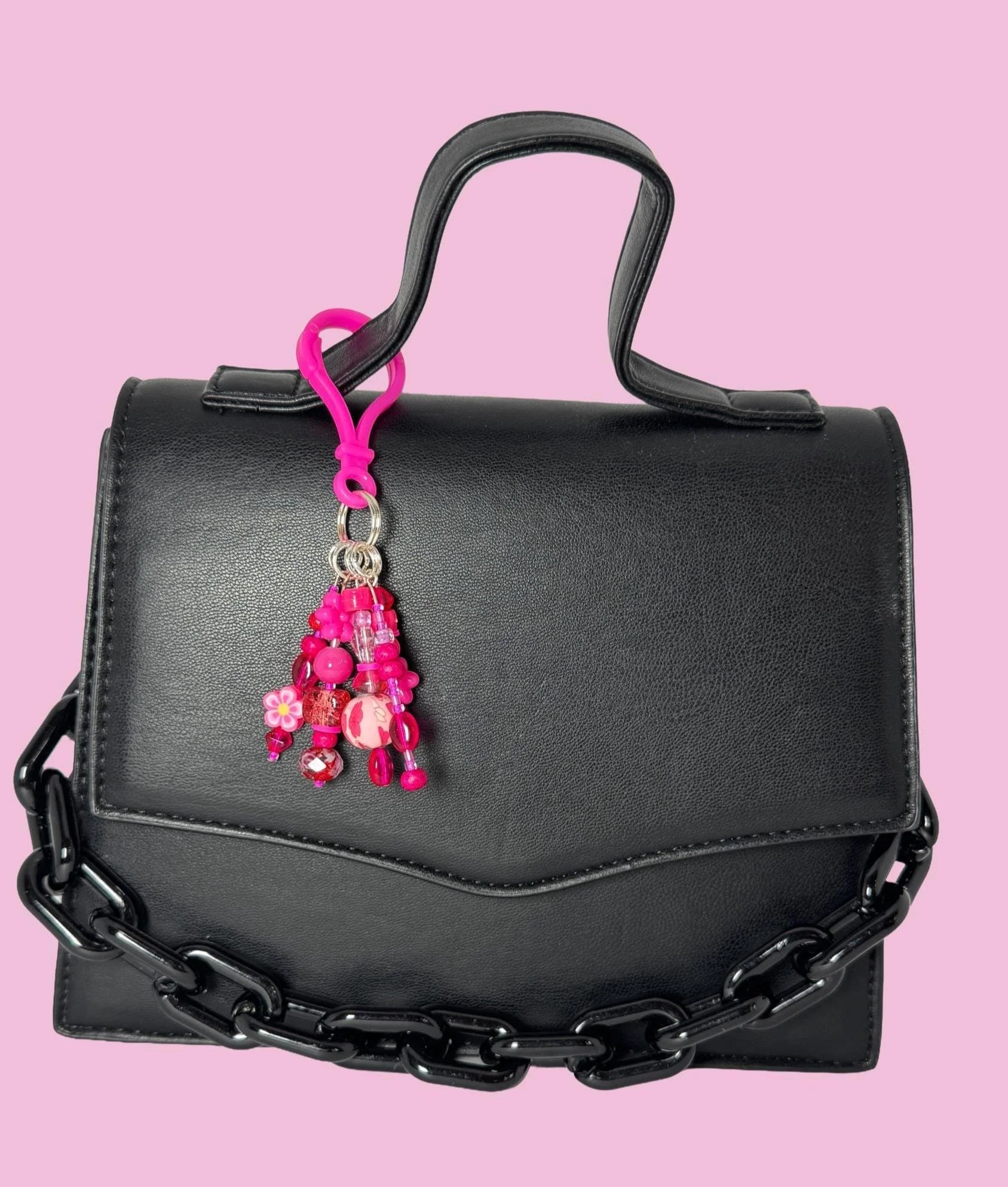 Hot pink charm on black bag