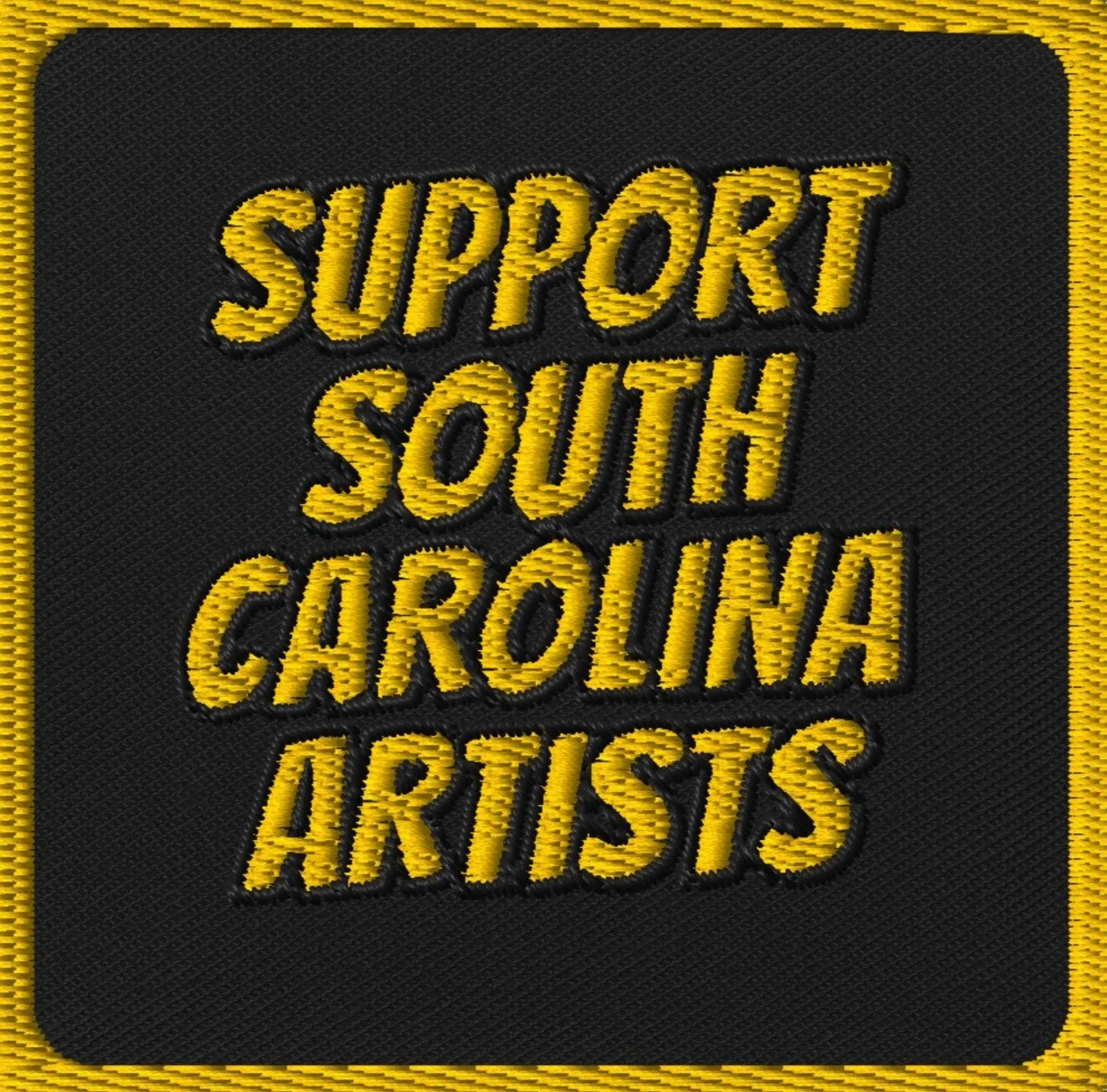 Embroidery patch with the text 'Support South Carolina Artists' in yellow on a black background, with a yellow border.