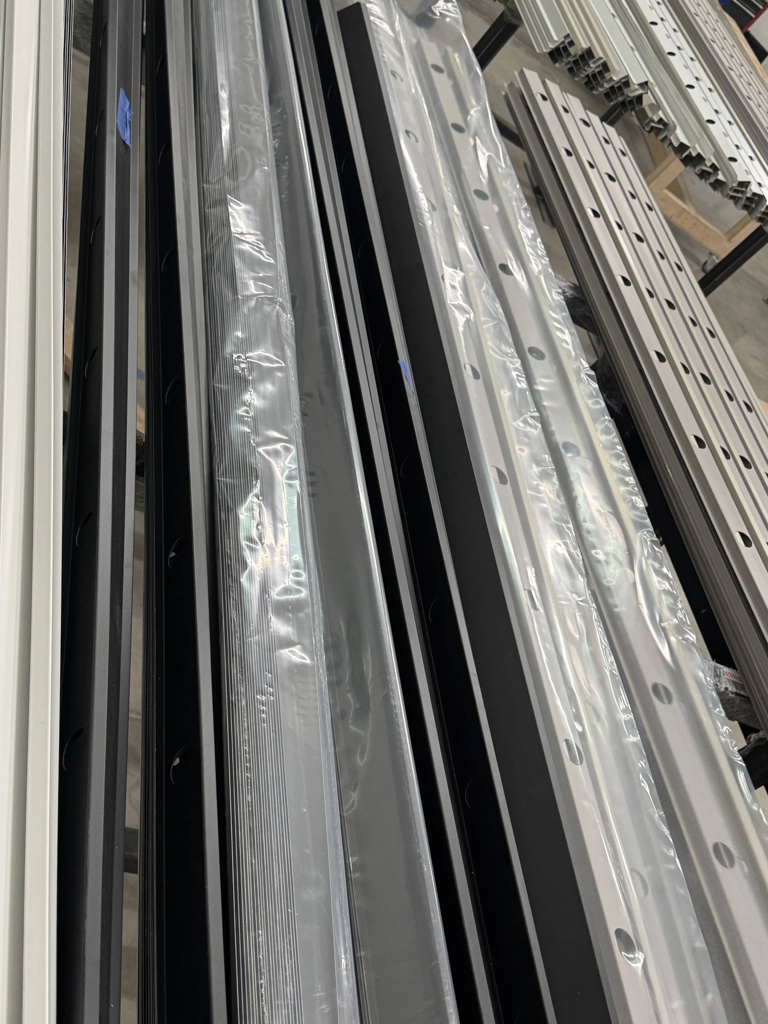 Stacked metal and aluminum components on a rack in an industrial or manufacturing setting.