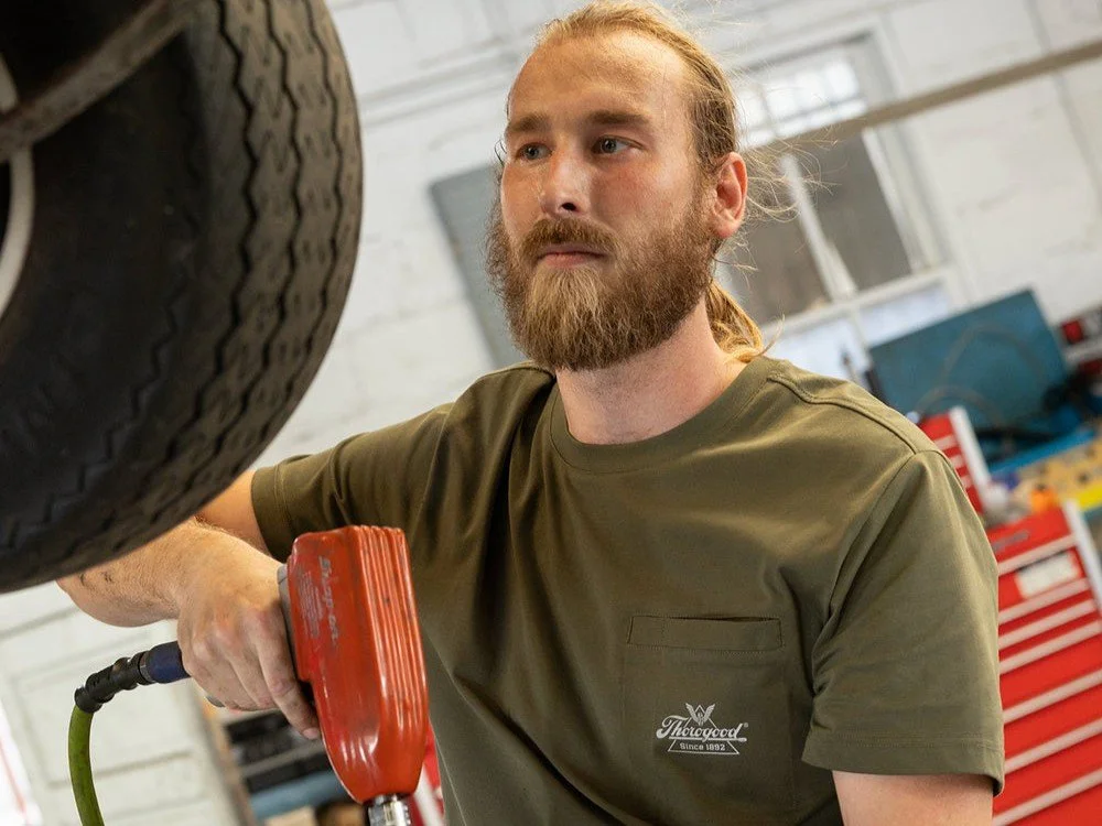 Mechanic performing advanced repairs on a vehicle while on a hydraulic car lift.