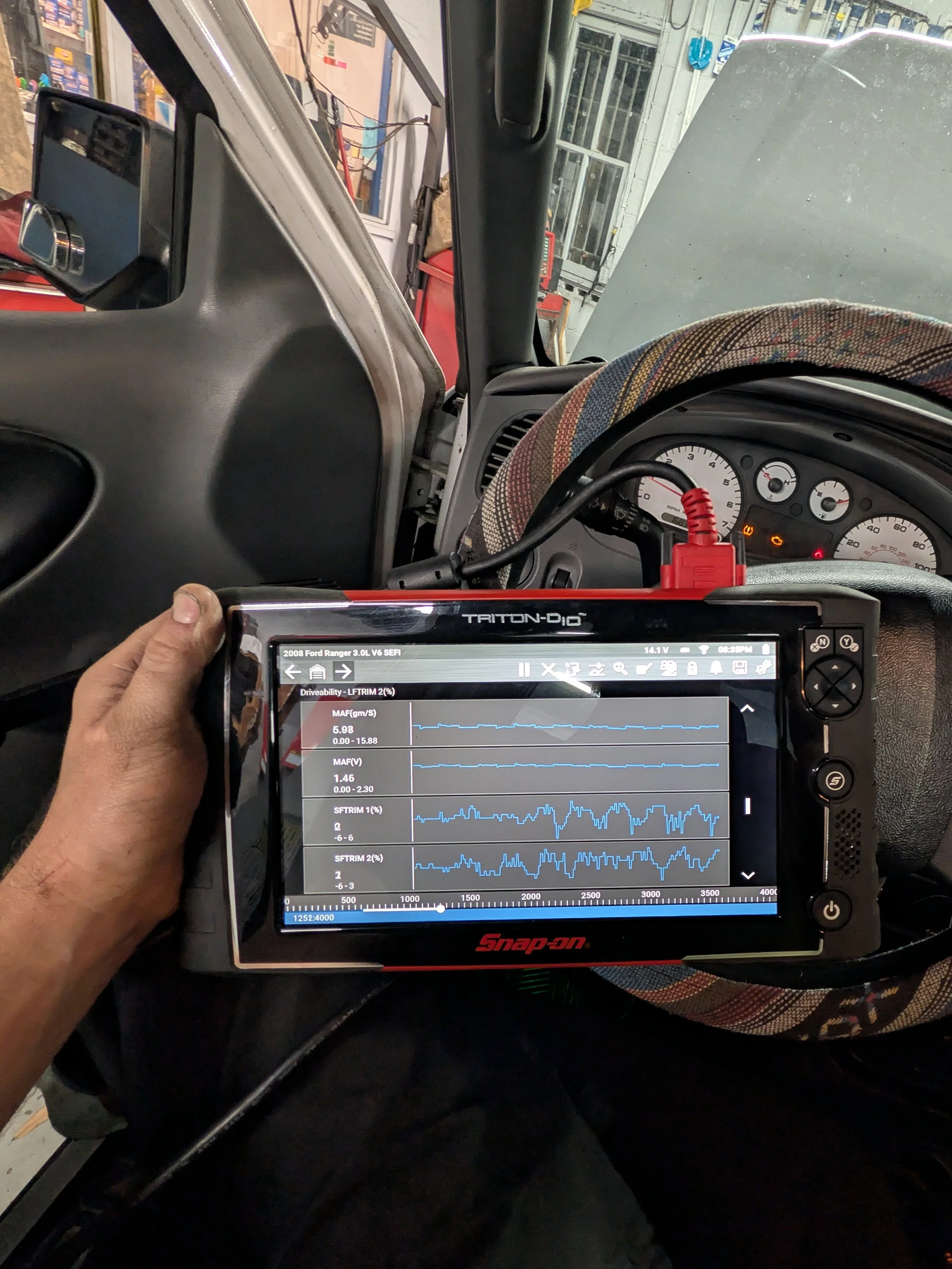 	
Technician performing high level computer diagnostics with a hand held tablet scan tool.