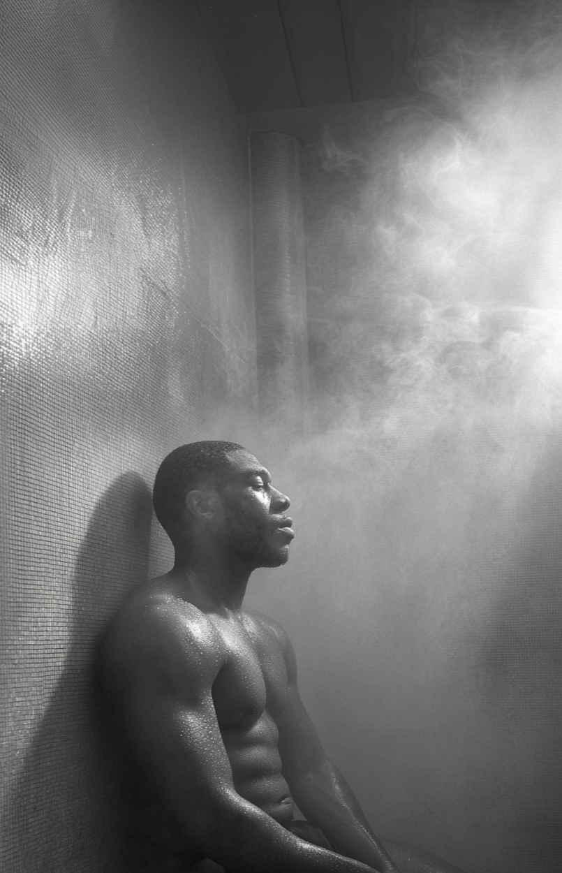 Man sitting in a steam room to benefit from the detoxing and relaxing qualities the room has to offer