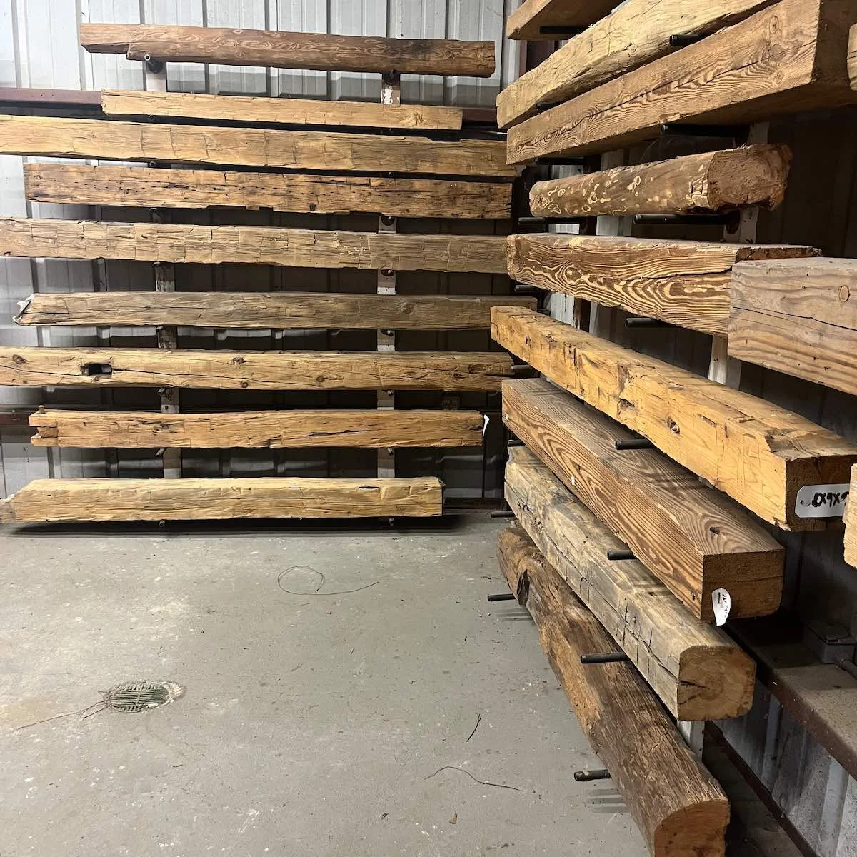 Antique reclaimed beam mantels, each showcasing unique aged patina and distinctive grain line patterns, highlighting their natural character.