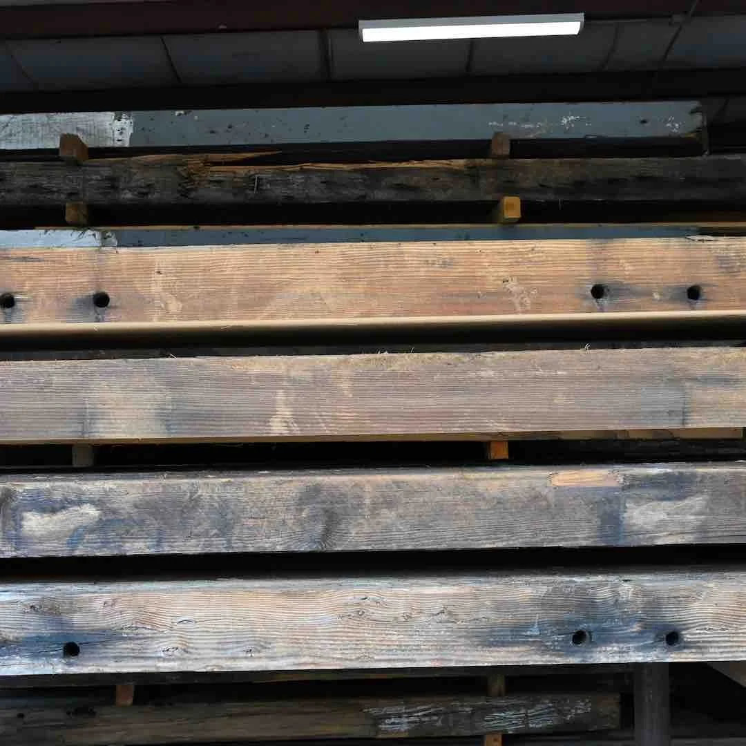 Thumbnail of stacked antique reclaimed industrial timbers with aged patina, weathered grain, and historic bolt holes.