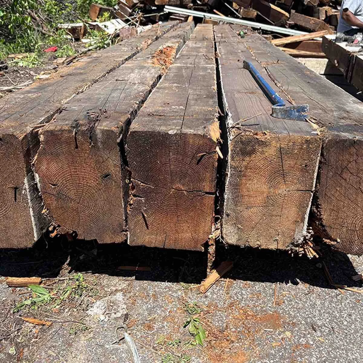 Antique reclaimed industrial timbers with visible growth rings and weathered ends.