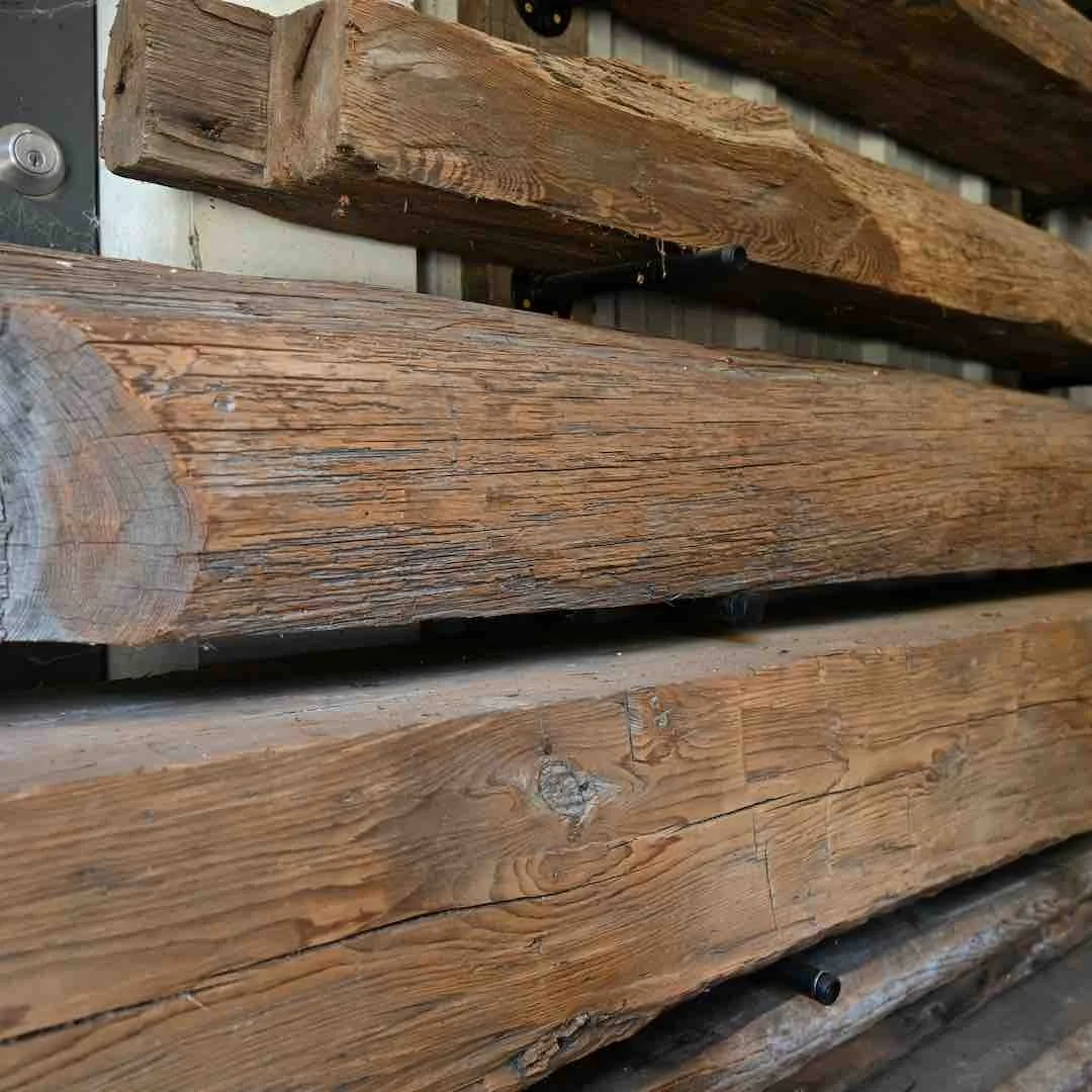 Thumbnail of antique reclaimed beam mantels showcasing both round and square surface shapes with visible tool marks, aged patina, and natural grain character.