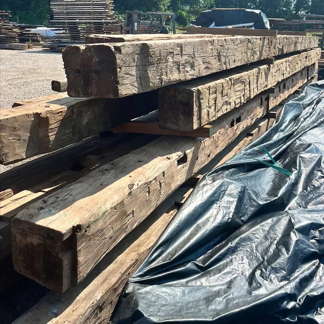 Thumbnail of antique reclaimed timber beams stacked outdoors, showing weathered grain texture and aged patina.