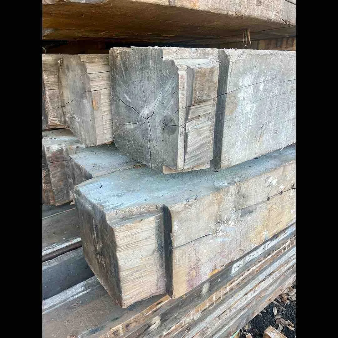 Thumbnail of antique reclaimed industrial timbers with visible end grain, aged surface cracks, and weathered patina stacked in storage.