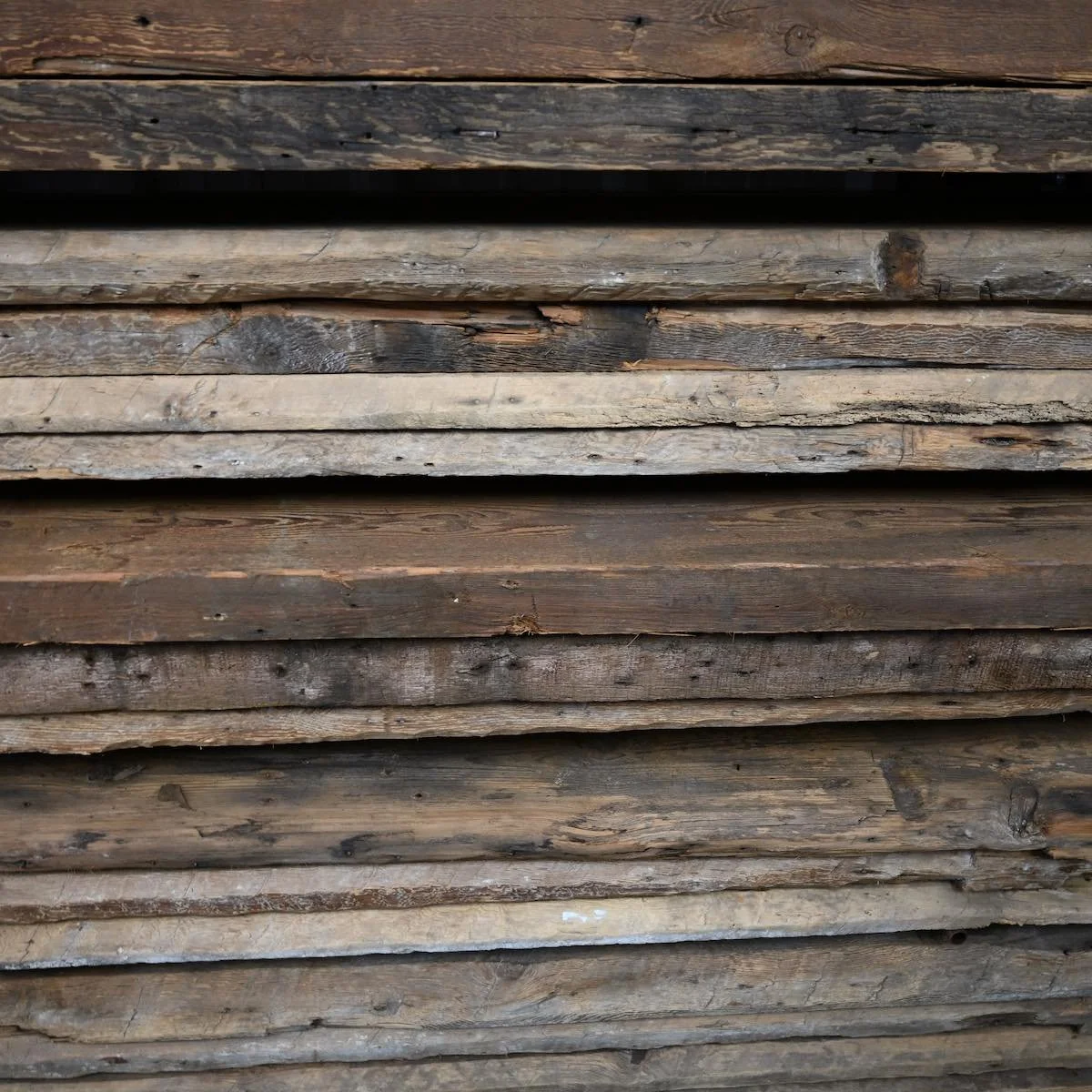 Stacked antique reclaimed floating shelf boards with natural patina and aged texture.