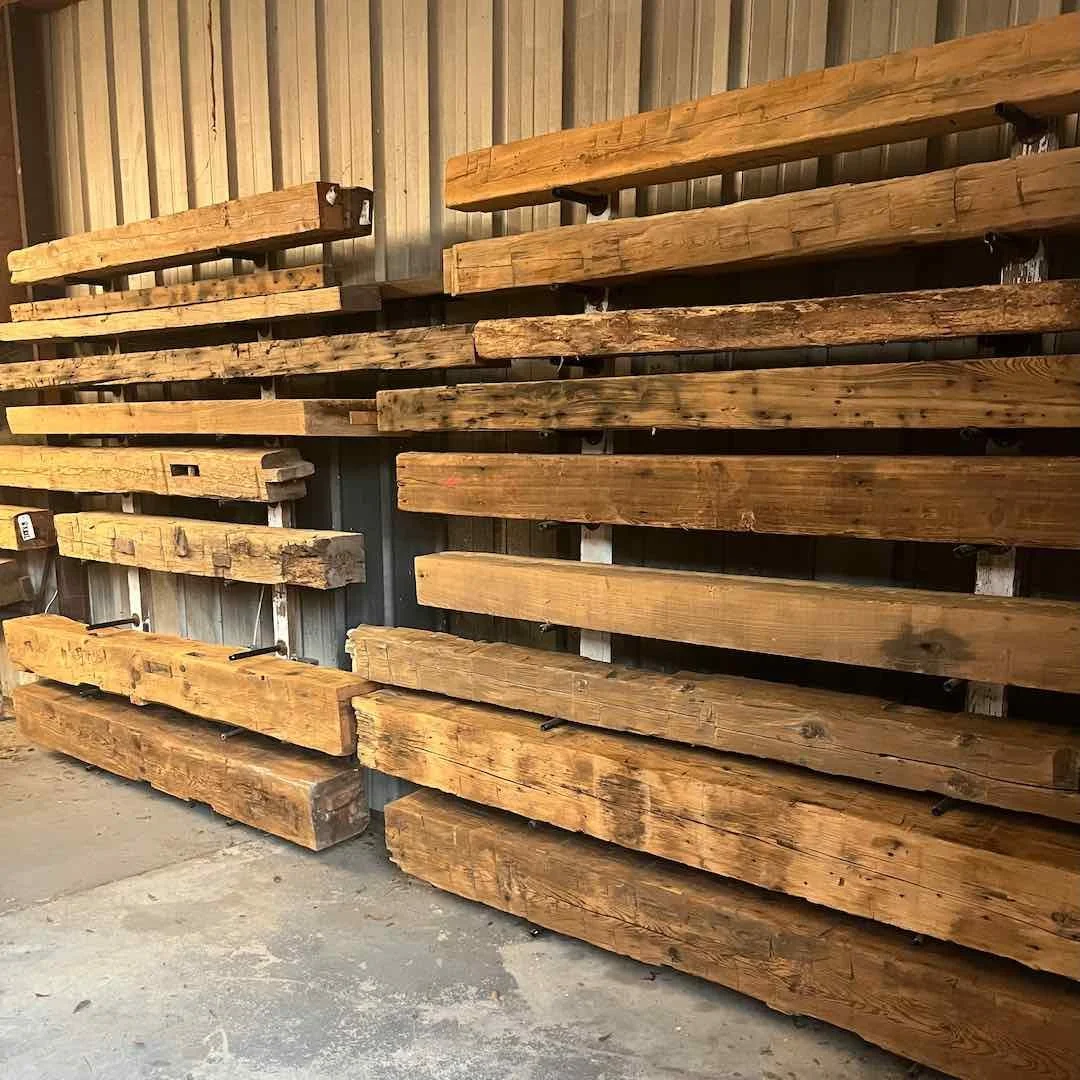 Thumbnail of antique reclaimed beam mantels, stacked on the wall, showcasing natural patina and weathered surface texture.