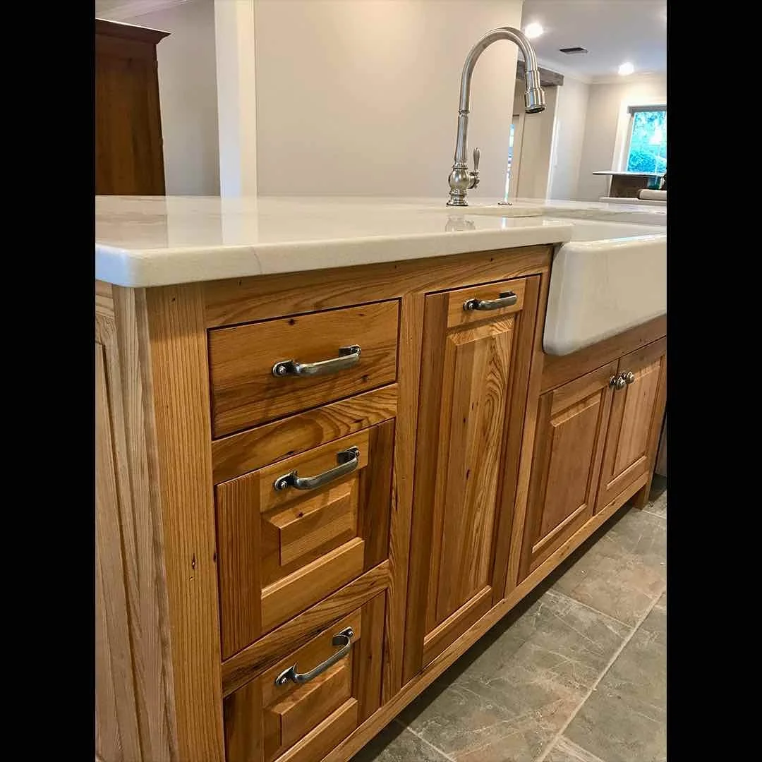 Antique reclaimed cypress wood kitchen cabinetry in a client's home, showing rich grain, warm patina, and farmhouse sink.