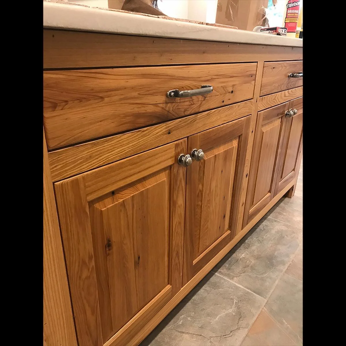 Antique reclaimed Tidewater red cypress cabinetry with natural grain patterns, warm tones, and handcrafted panel doors, highlighting its durability and timeless character.