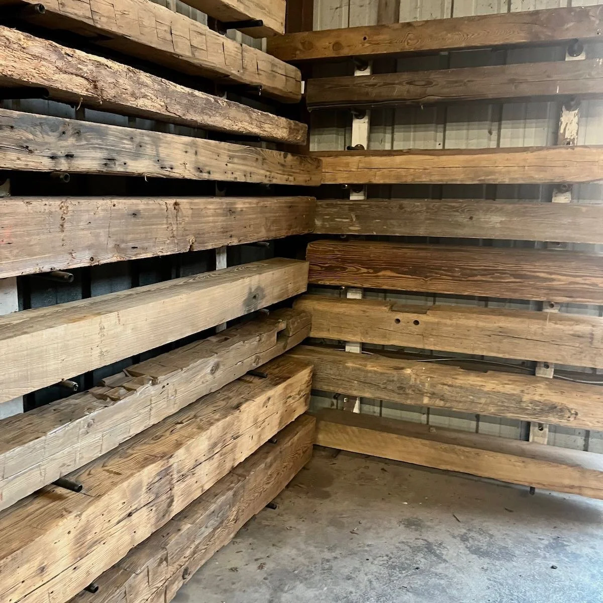 Antique reclaimed beam mantels with natural patina and tool-marked surface.