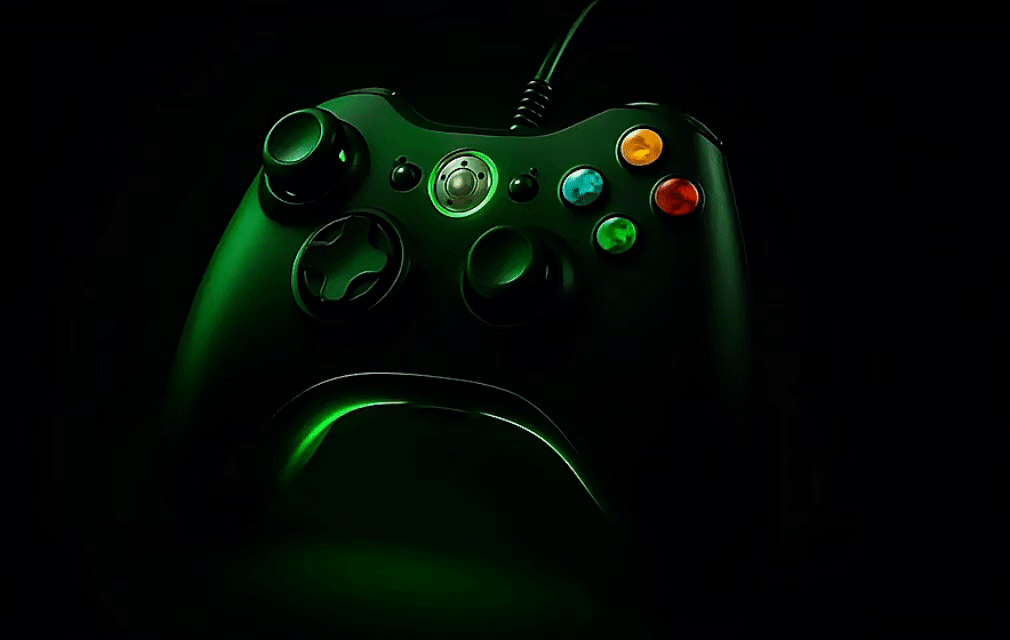 Black game controller with colored buttons and green LED lighting, illuminated against a dark background.