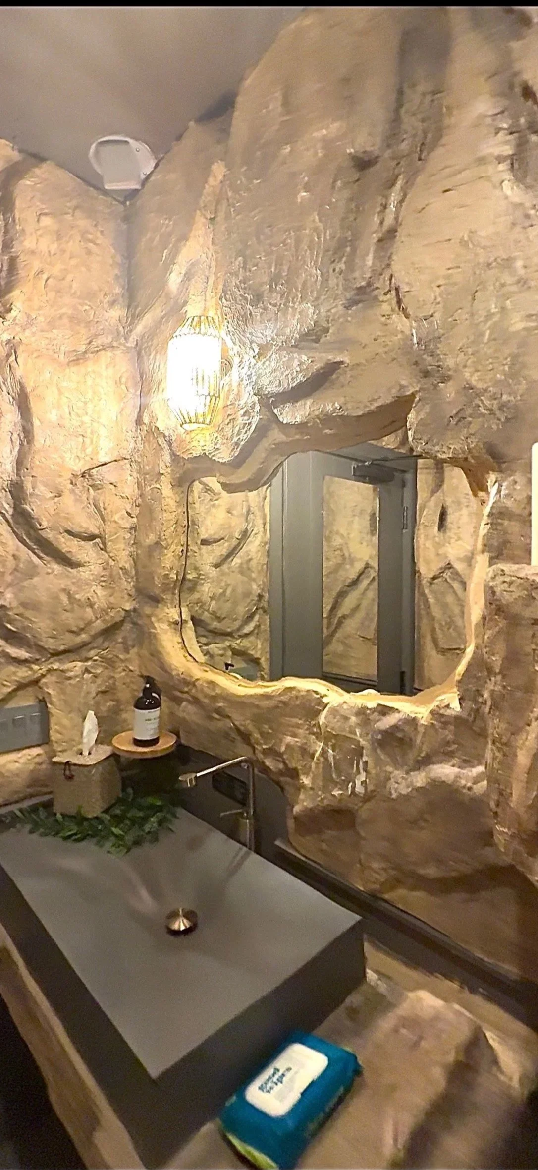 Custom sculpted stone bathrooms by Reimagining Spaces Studio for Nourish in the Bronx, featuring handcrafted organic textures inspired by Tulum luxury design.