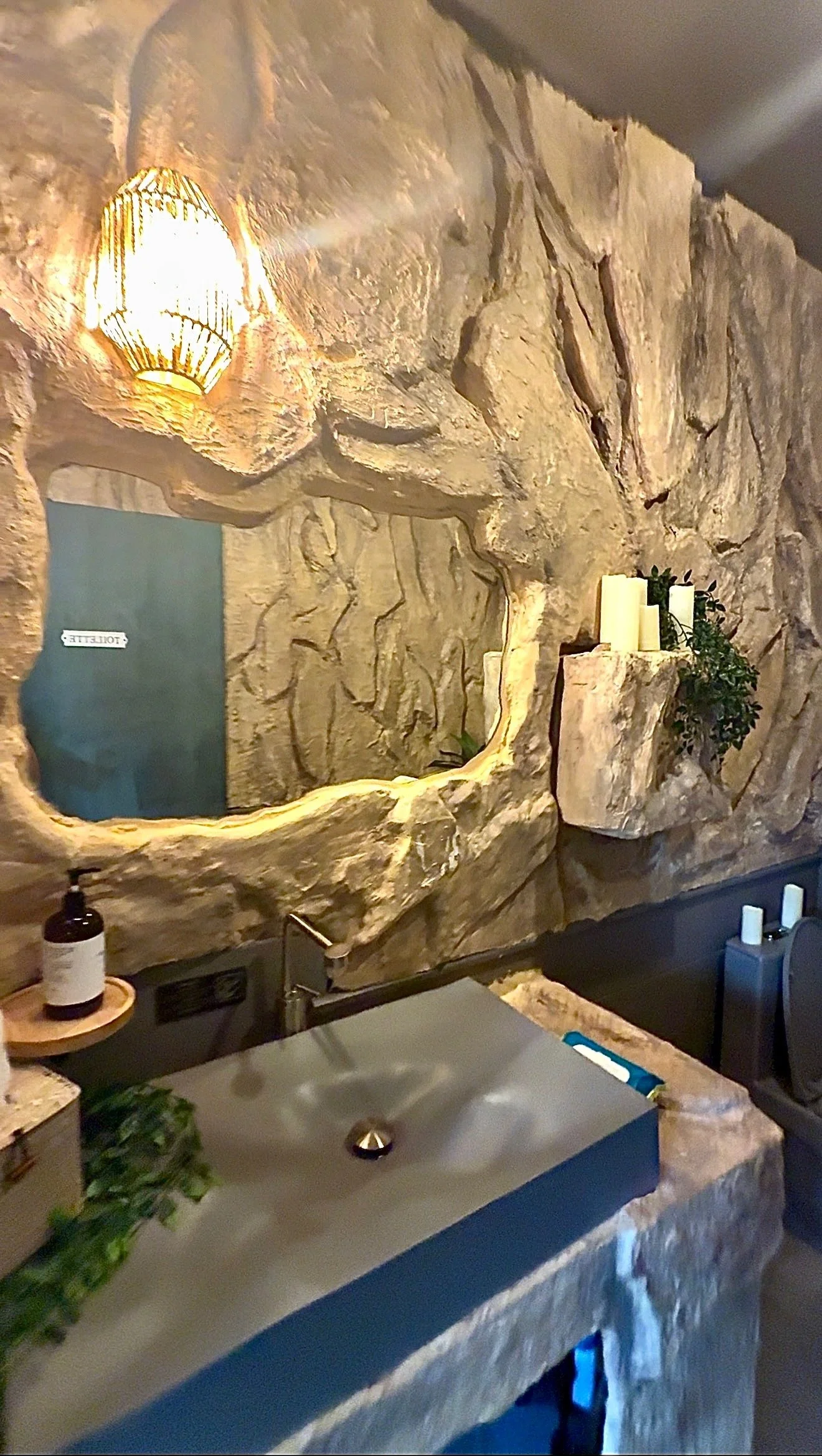 Custom sculpted stone bathrooms by Reimagining Spaces Studio for Nourish in the Bronx, featuring handcrafted organic textures inspired by Tulum luxury design.