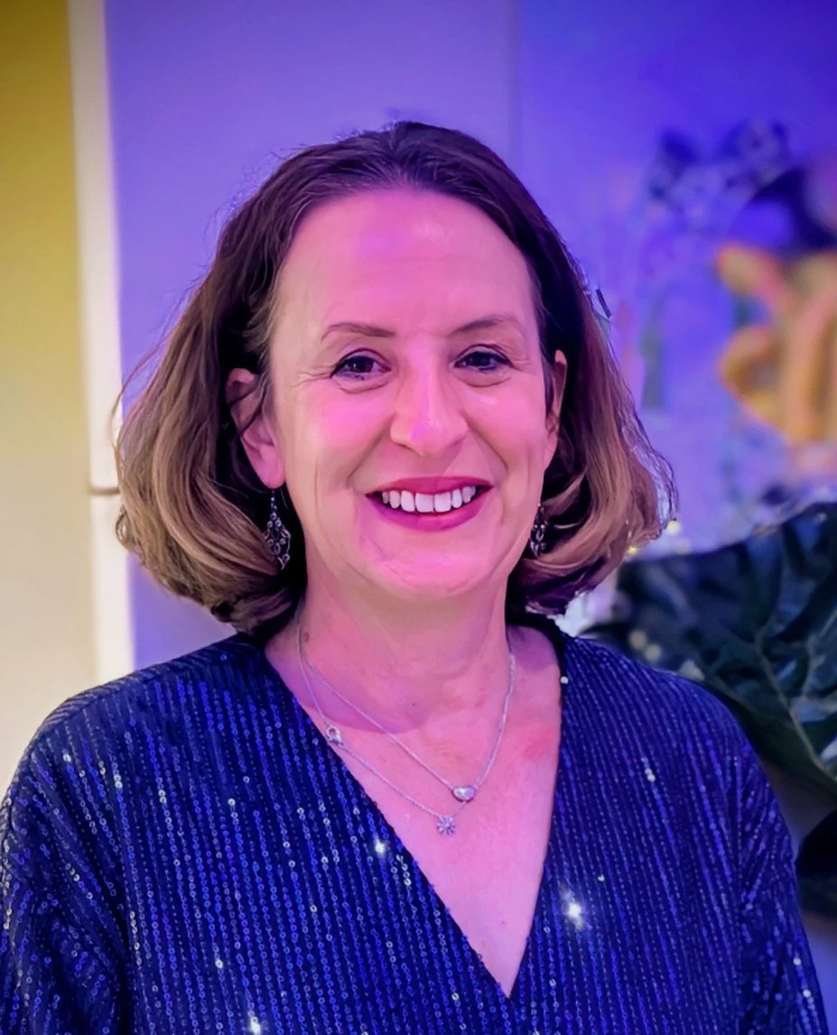 Photo of Karyn with brown short hair wearing a blue dress