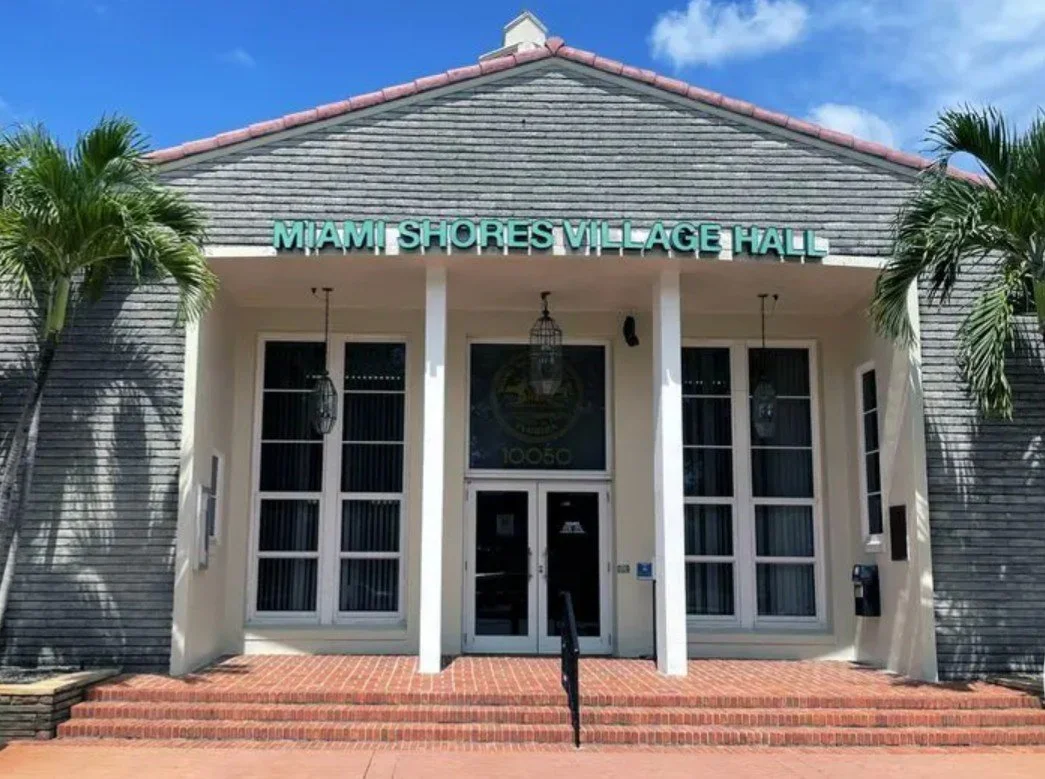 A daytime view of the Miami Shores Village Hall with its brick stairs and columns, highlighting an area where Mobile IV Nurse provides mobile IV therapy.