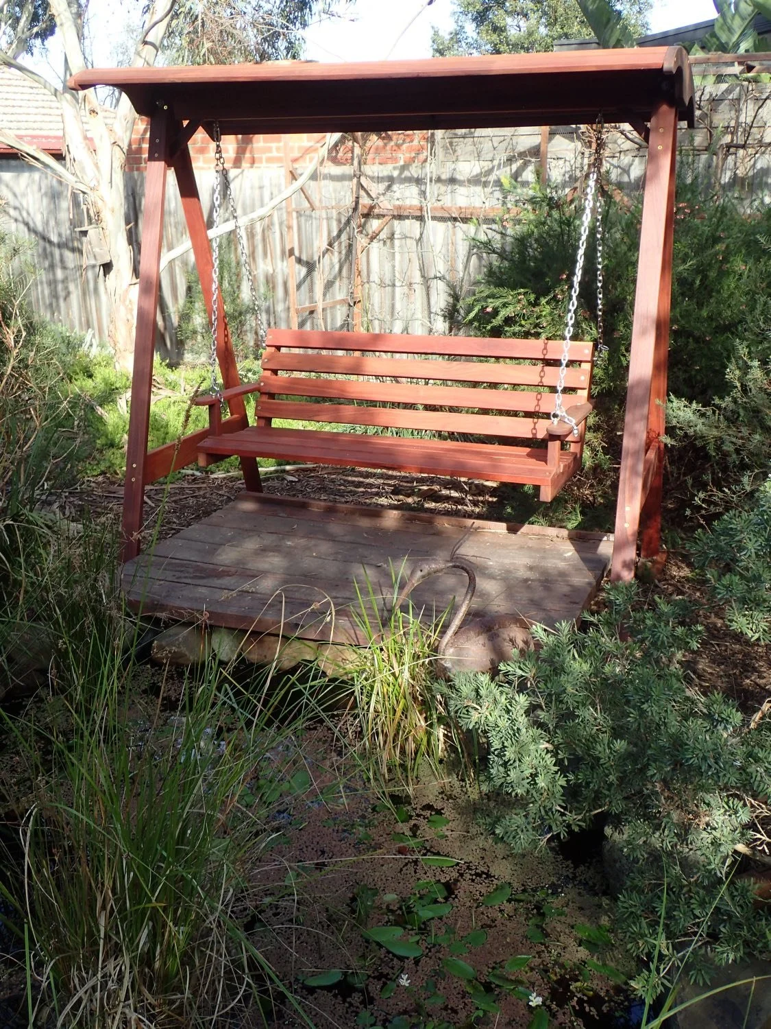 3 seat Horizontal slat shaped seat Jarrah swing  over looking  the customers pond