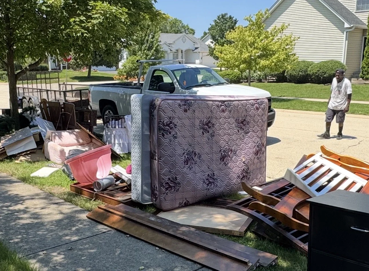 Furniture and household items staged for junk removal during a Oswego, Illinois property cleanout.
