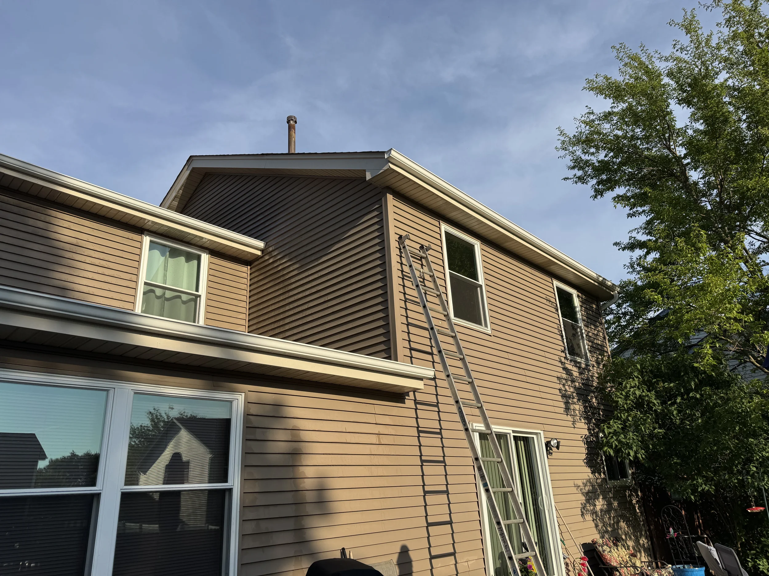 Ladder set up for residential gutter cleaning at a two-story home in Aurora, Illinois.