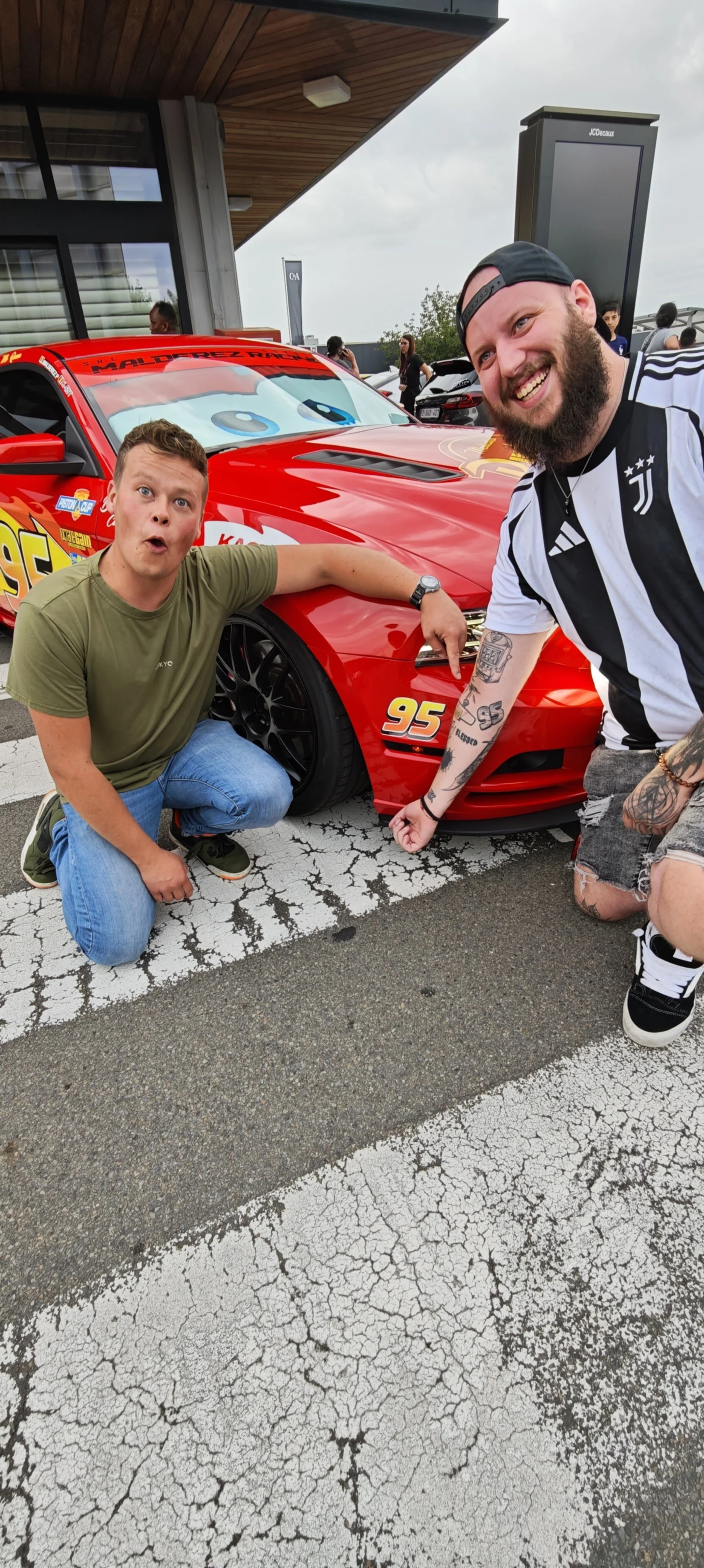 Pierre Malderez posent avec un abonné possèdent un tatouage de Flash Mcqueen dans Cars devant sa voiture de course rouge inspirée du dessin animé . Je suis rapide