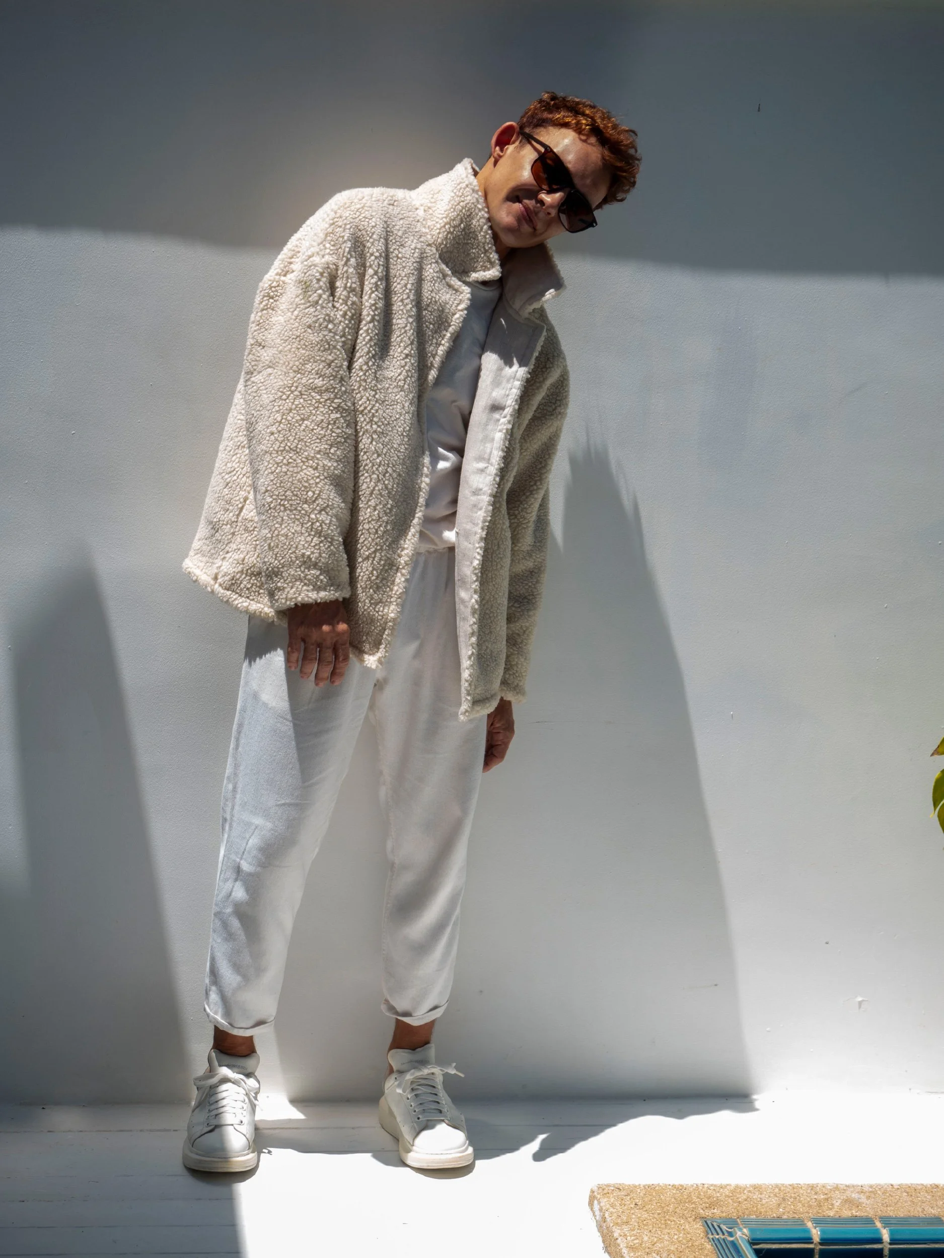 model wearing beige boxy parka sewn as a jacket with collar and sherpa lining turned inside out ( reversible)