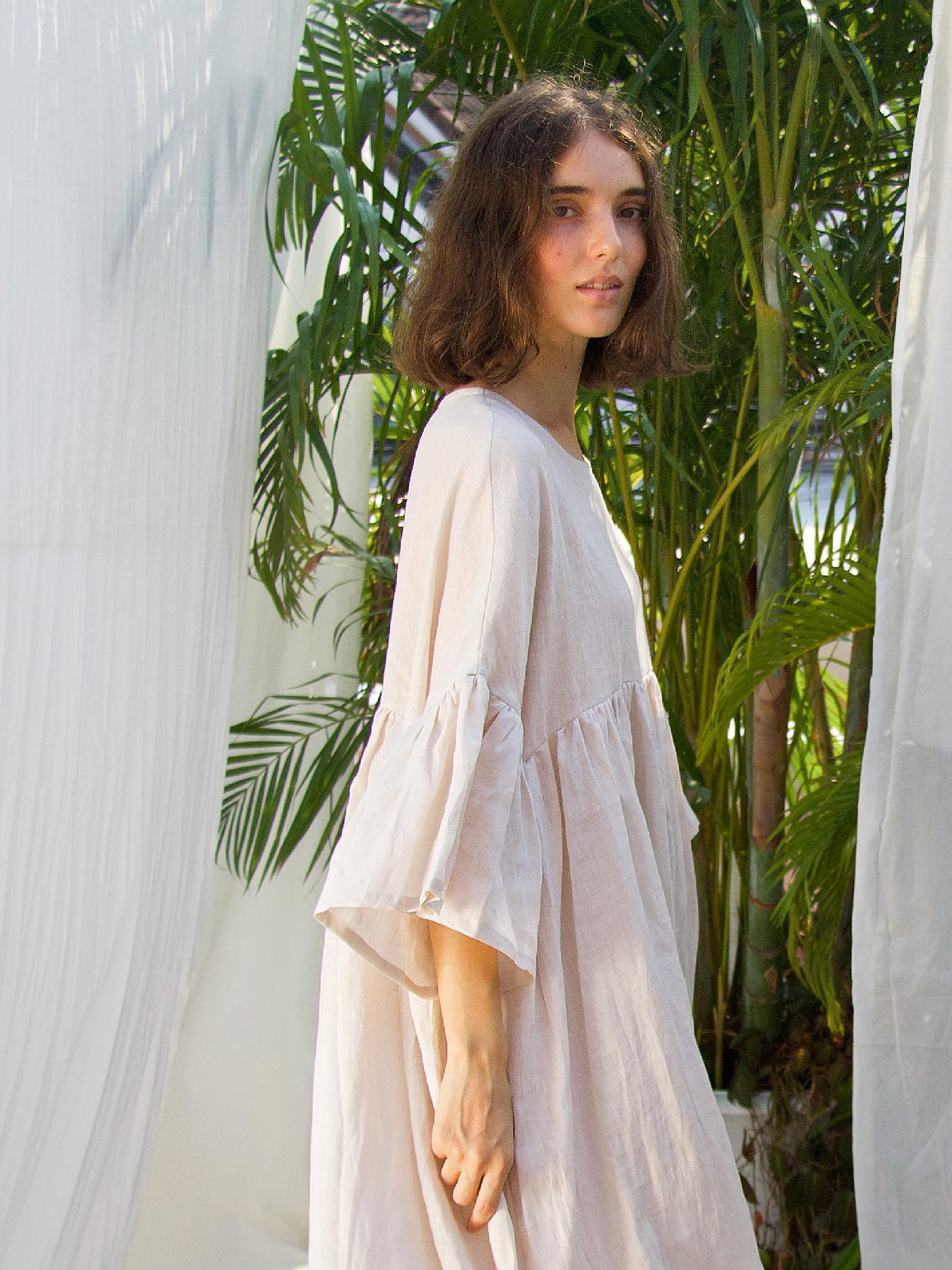portrait of model wearing soft pink linen aria dress