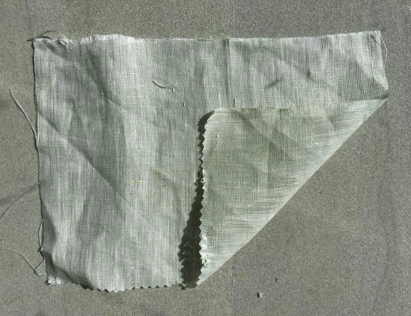 light green linen with one corner flipped over to reveal the wrong side of the farbric - which looks totally similar to the right side