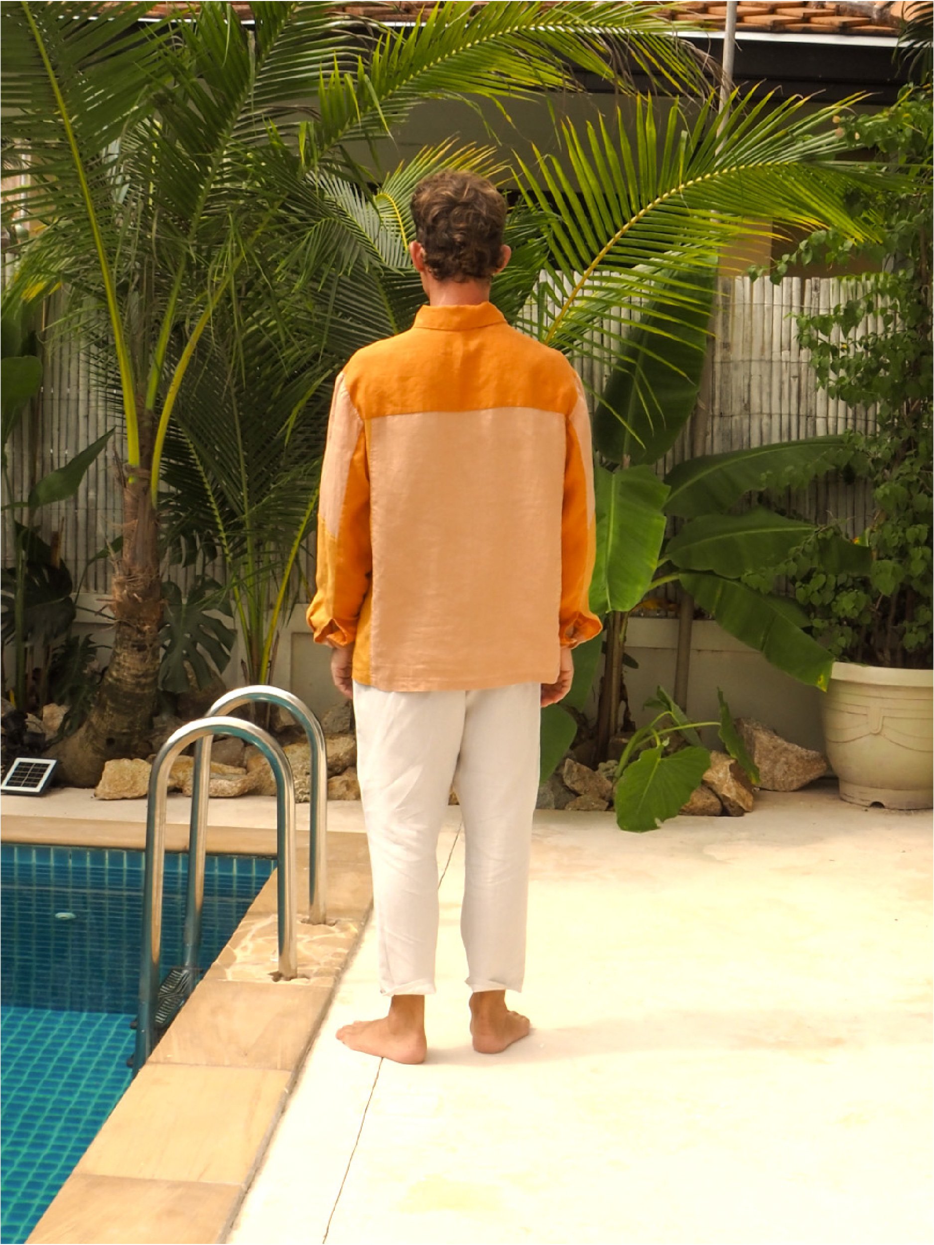 model wearing orange patch pocket adventure shirt - back view
