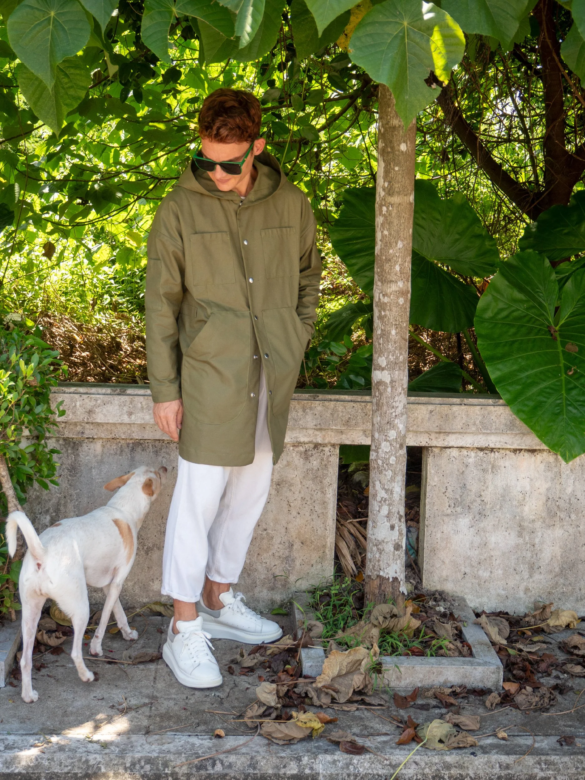 model wearing green boxy parka with hood buttoned up