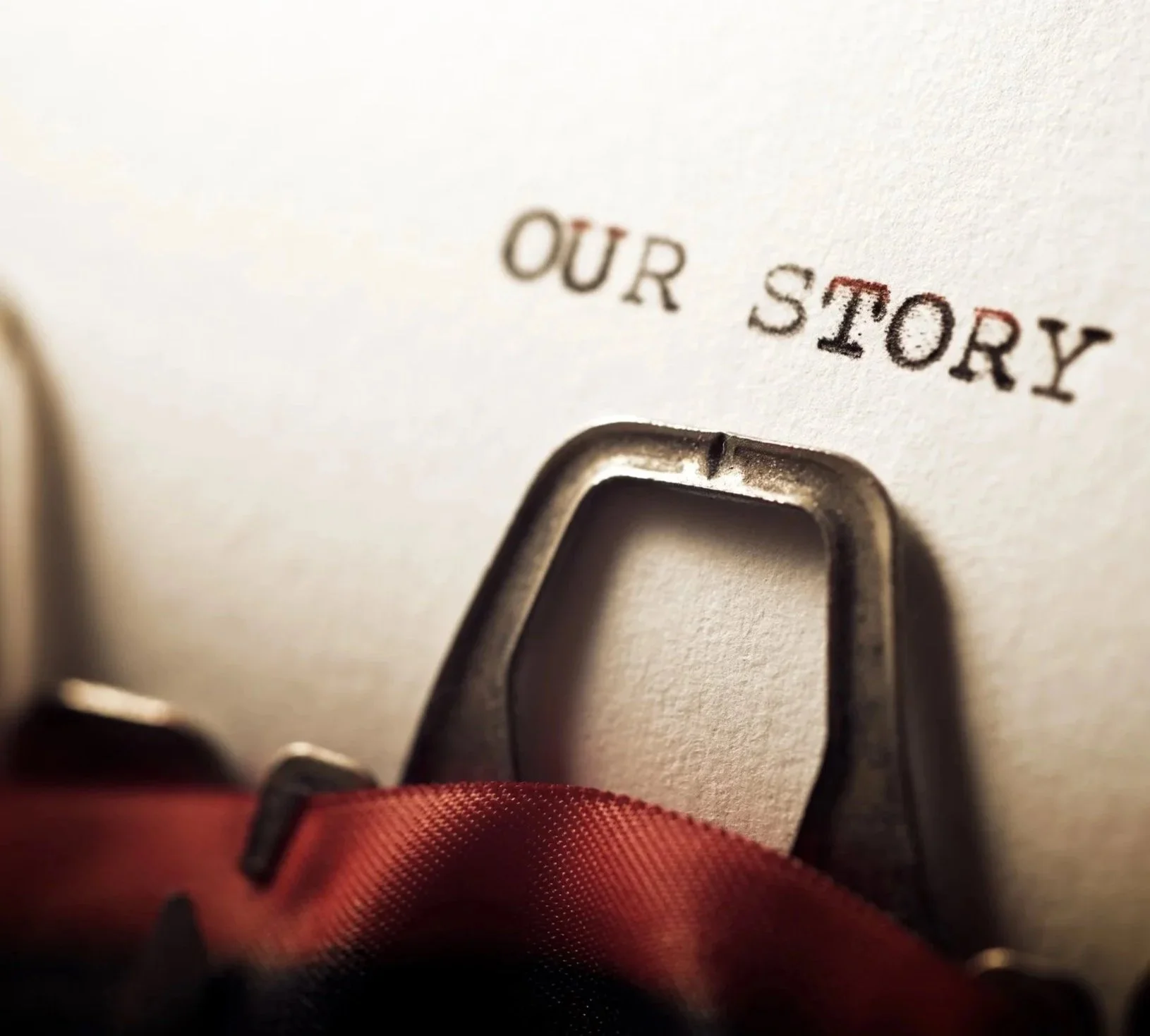 Close-up of a typewriter with the words 'OUR STORY' typed on the paper.