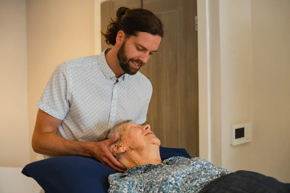 Josh Kelsall, registered osteopath, performing hands-on neck treatment at JMK Osteopathy clinic in Sheffield