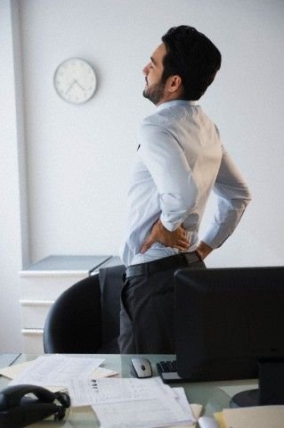 Person experiencing lower back pain, a condition treated at JMK Osteopathy in Sheffield
