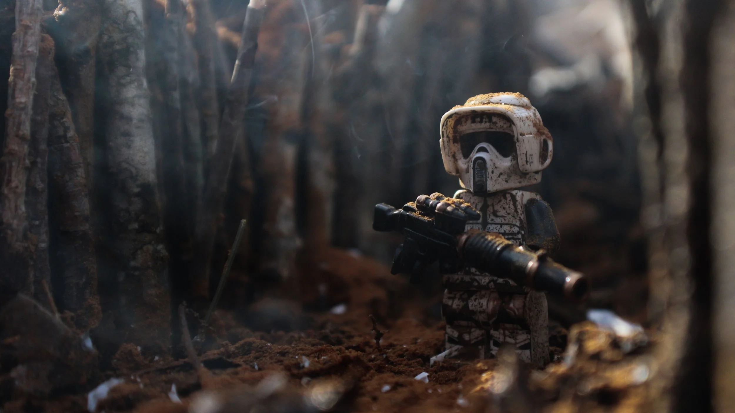 A LEGO Stormtrooper figure with a dirty, weathered appearance holding a blaster, set in a dark, forest-like environment with brown soil and tree bark.