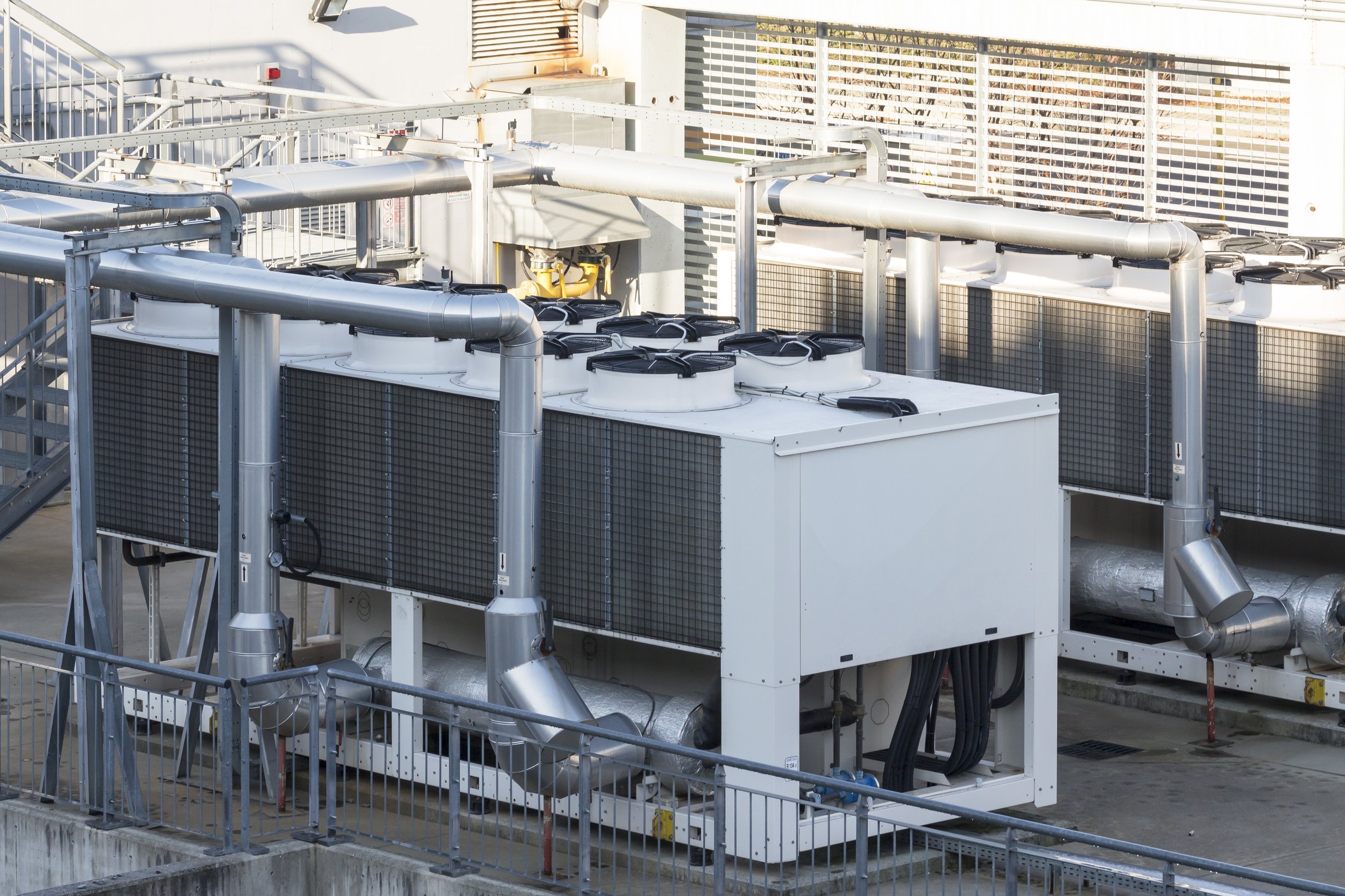 Industrial HVAC units and piping on a rooftop.