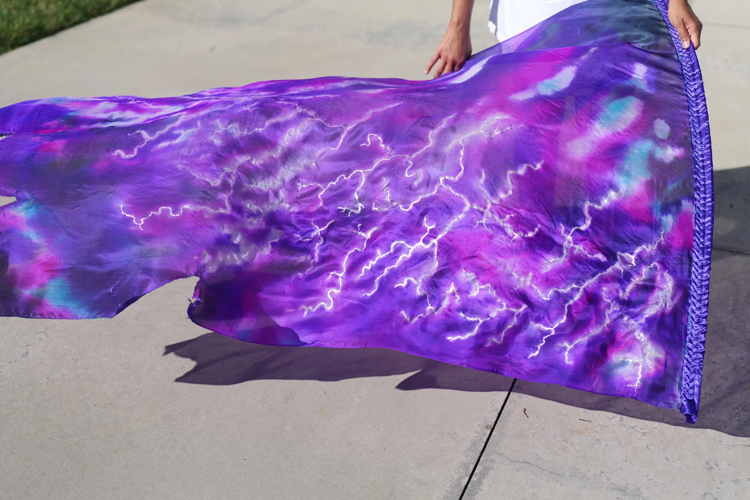 Close-up of a blue Tallit with white Hebrew embroidery.